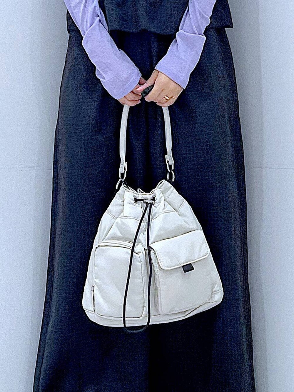 ホワイト系のハンドバッグ、ブラック系のサロペット/オーバーオール、パープル系のTシャツ/カットソーを着用したレディースの秋コーディネートの9枚目の写真