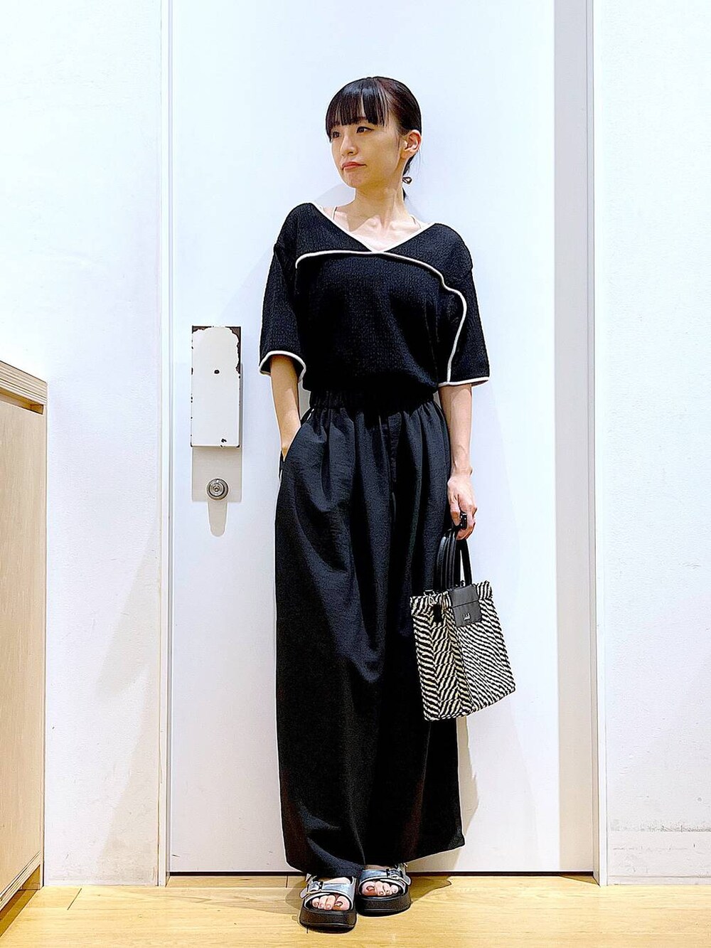 シルバー系のサンダル、ブラック系のショルダーバッグ、ブラック系のその他パンツを着用したレディースの夏コーディネートの2枚目の写真