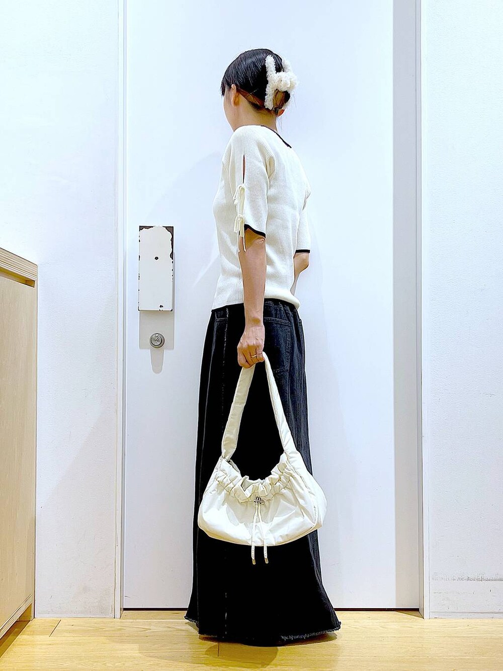 ホワイト系のハンドバッグ、ブラック系のローファー、ホワイト系のニット/セーターを着用したレディースの秋コーディネートの3枚目の写真