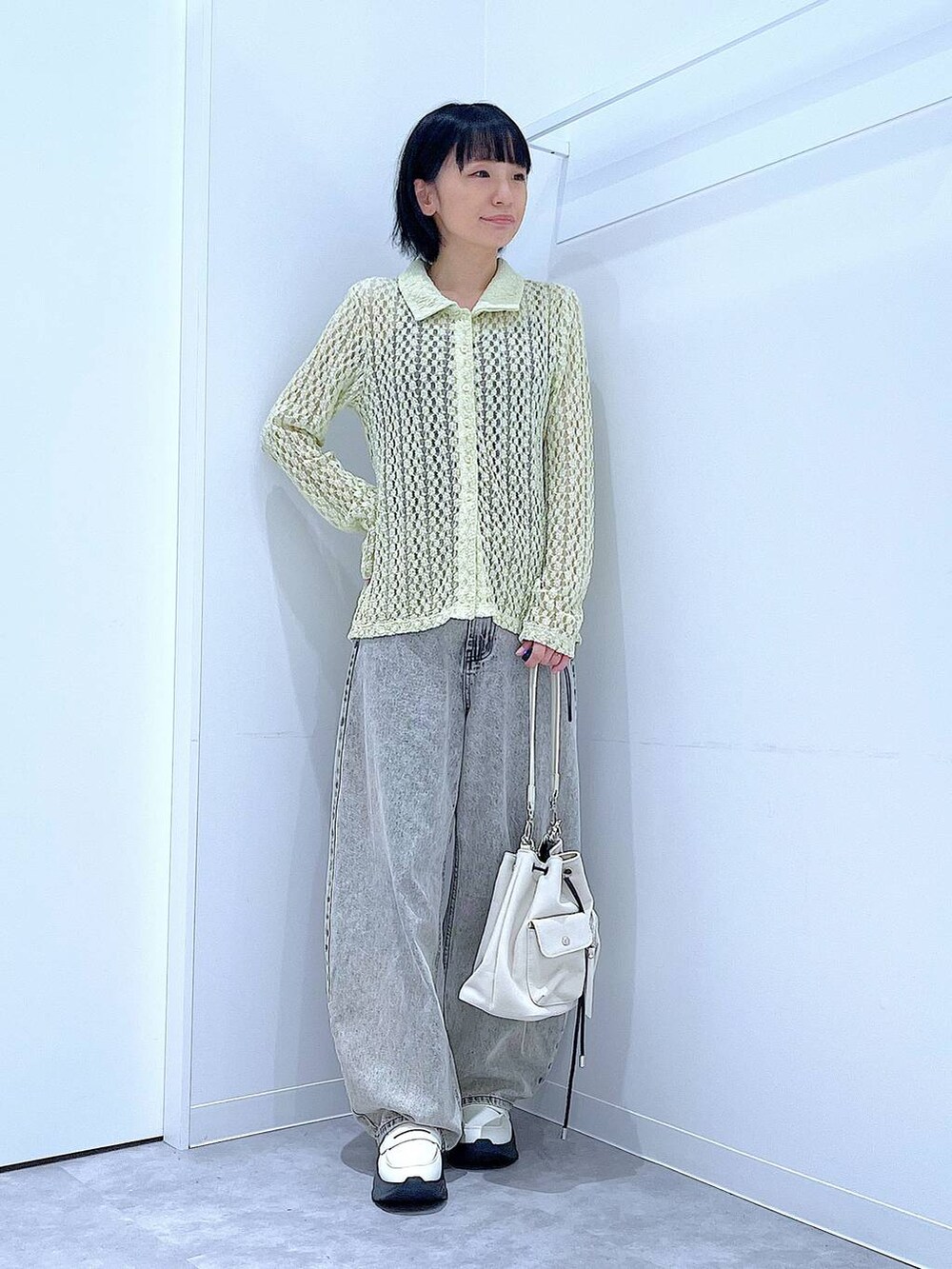 ベージュ系のデニムパンツ、ホワイト系のローファー、ホワイト系のショルダーバッグを着用したレディースの秋コーディネートの2枚目の写真