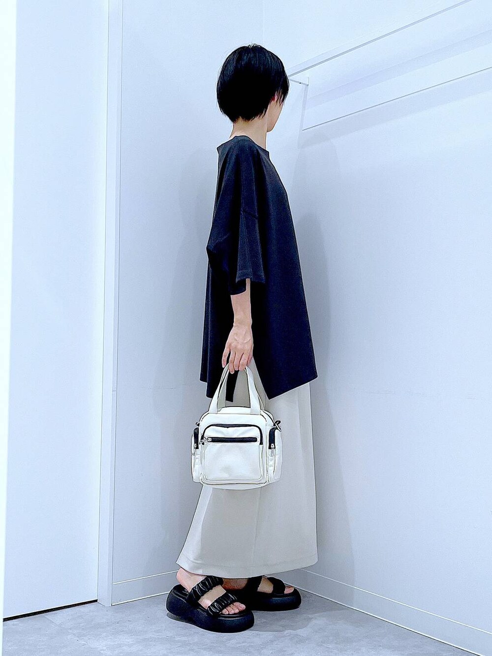 ブラック系のサンダル、ベージュ系のスカート、ホワイト系のショルダーバッグを着用したレディースの夏コーディネートの4枚目の写真