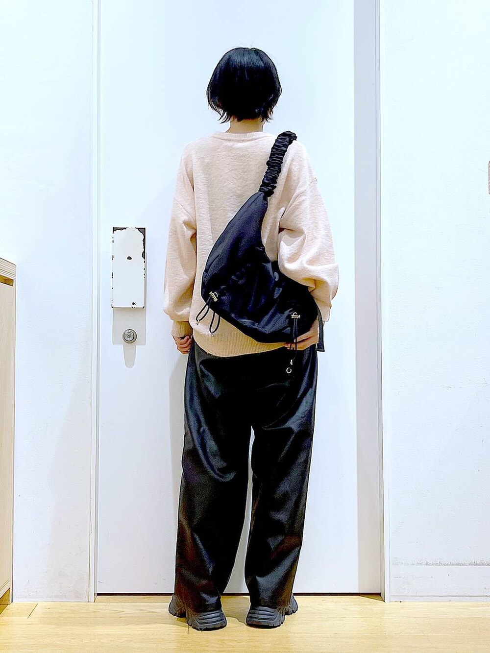 ブラック系のショルダーバッグ、ブラック系のブーツ、ブラック系のその他パンツを着用したレディースの冬コーディネートの5枚目の写真