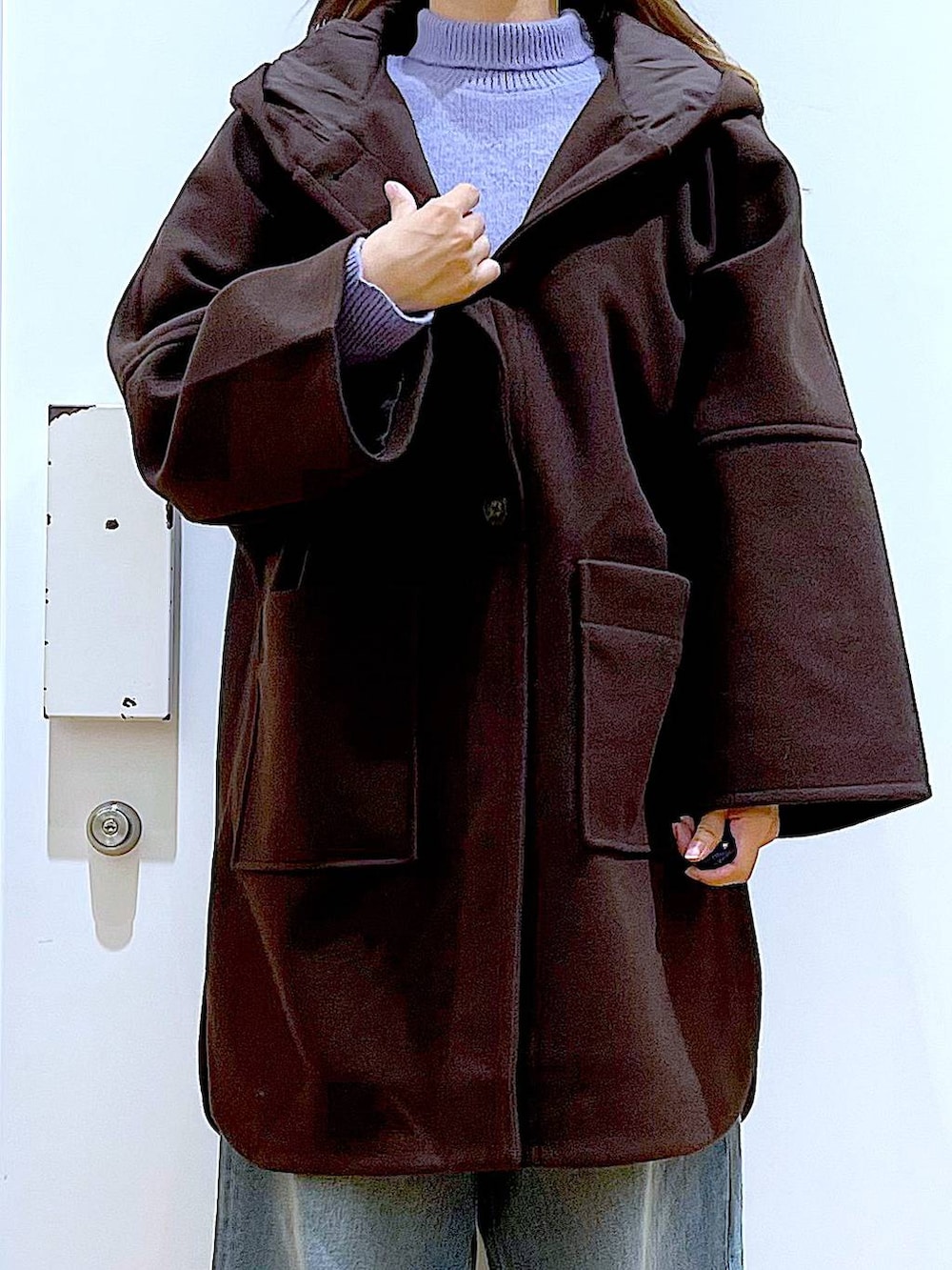 ブラウン系のその他アウター、ベージュ系のスニーカー、ブルー系のデニムパンツを着用したレディースの冬コーディネートの7枚目の写真