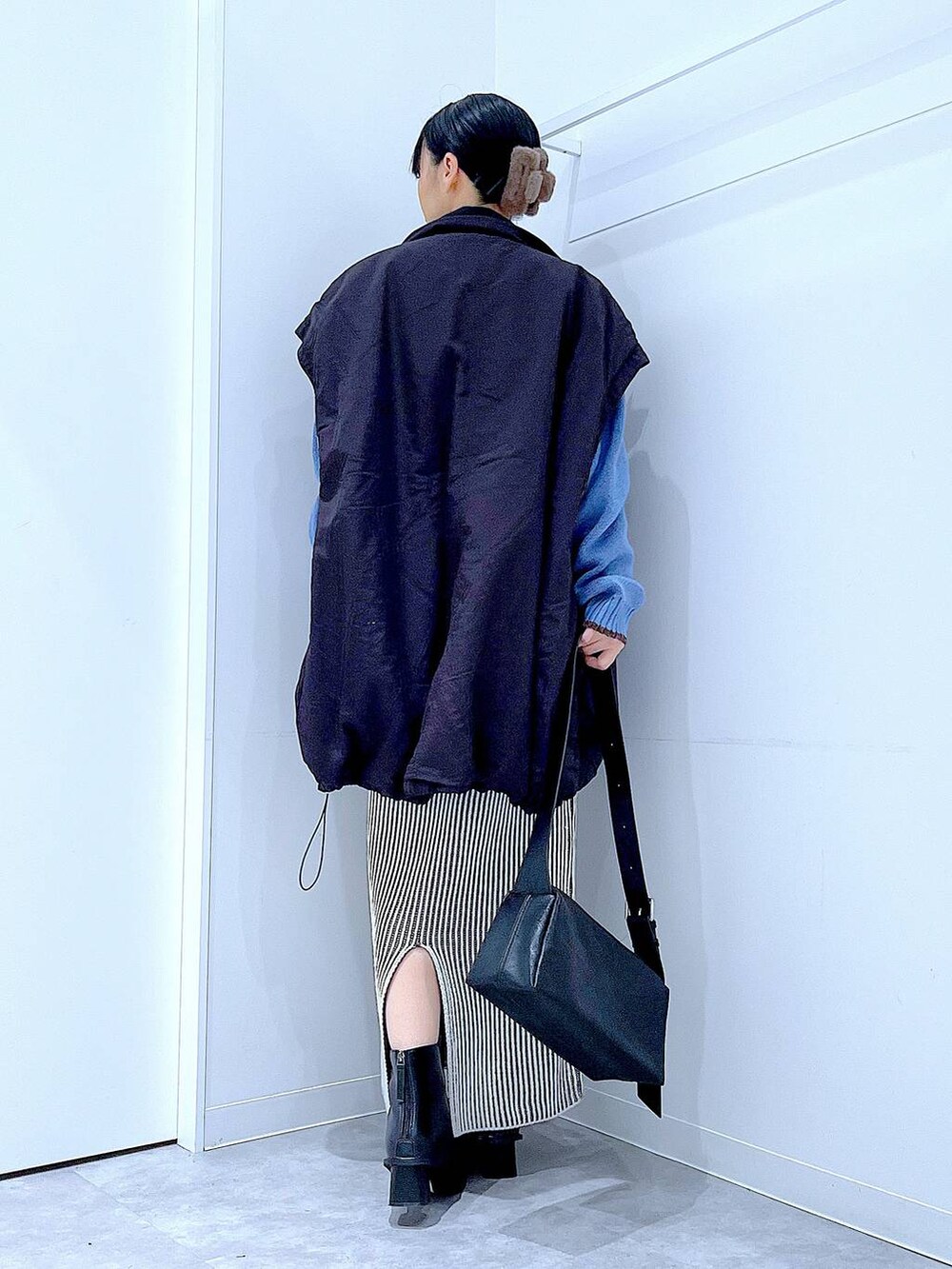 ブラック系のブルゾン、ベージュ系のスカート、ブラック系のブーツを着用したレディースの冬コーディネートの5枚目の写真