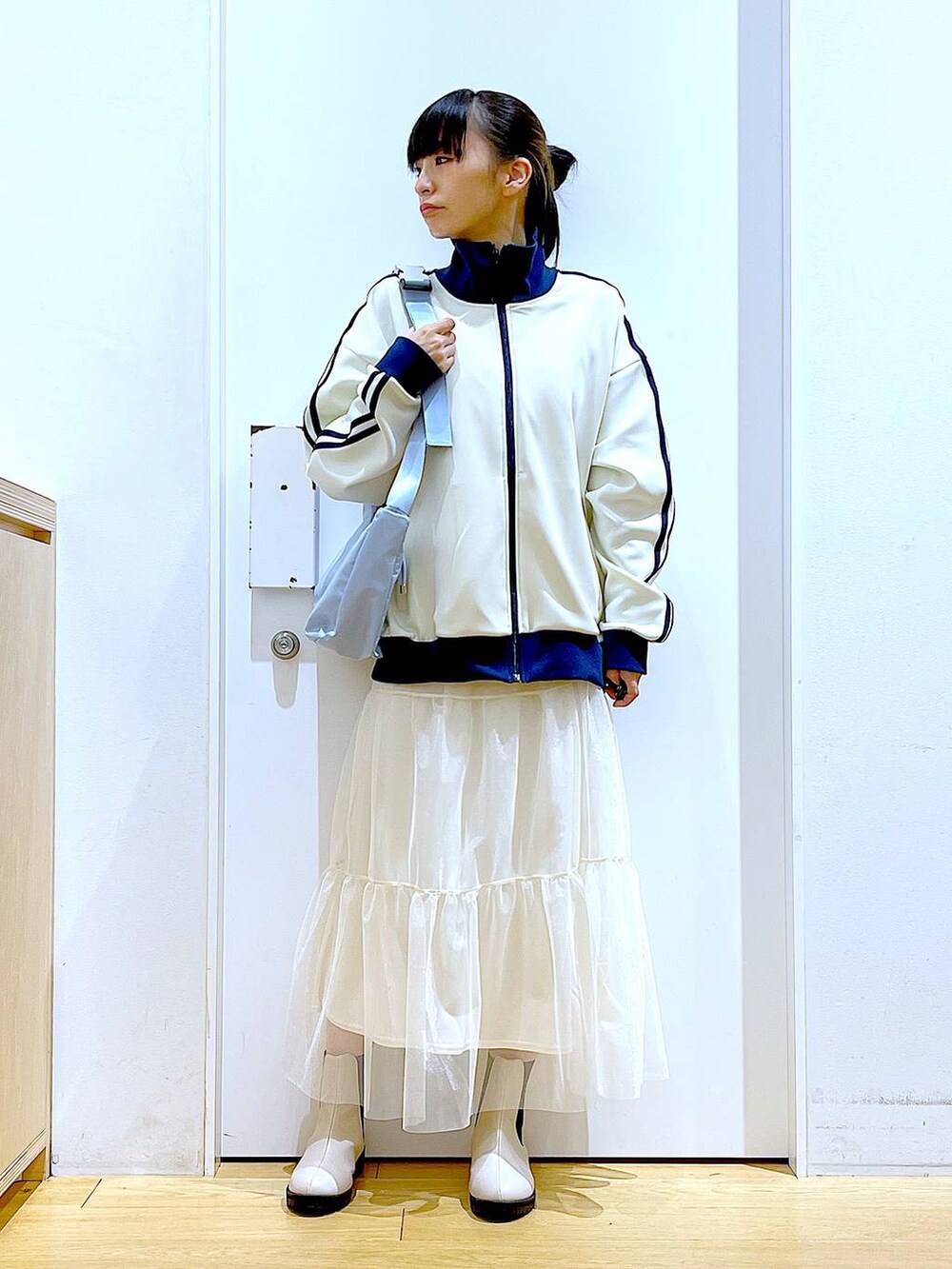 ベージュ系のブーツ、ブルー系のショルダーバッグ、ベージュ系のスウェットを着用したレディースの春コーディネートの2枚目の写真