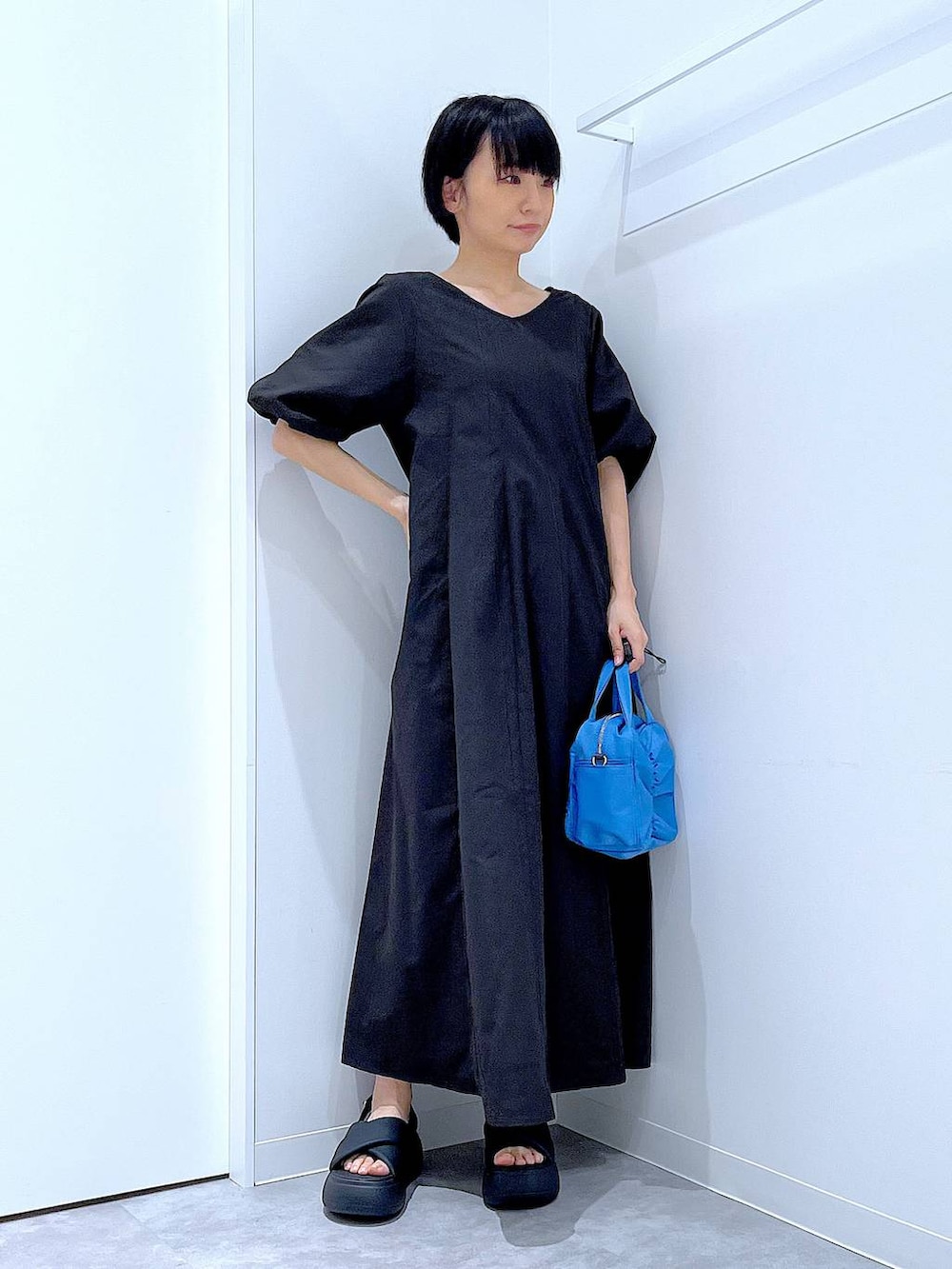 ブラック系のサンダル、ブラック系のワンピースを着用したレディースの夏コーディネートの2枚目の写真