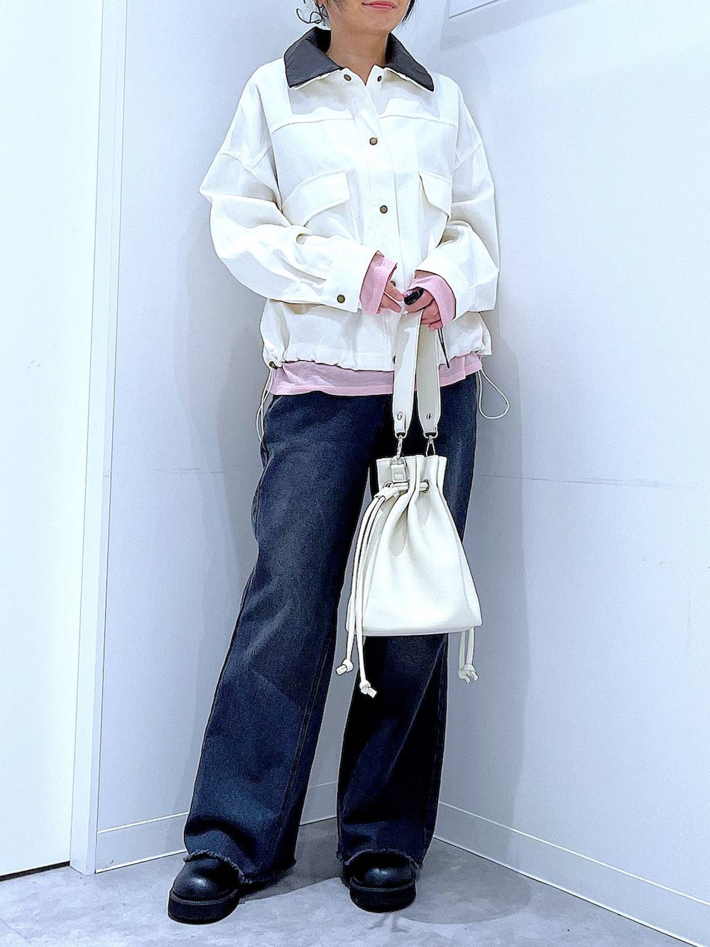 ピンク系のTシャツ/カットソー、ブラック系のデニムパンツ、ホワイト系のショルダーバッグを着用したレディースの春コーディネートの6枚目の写真