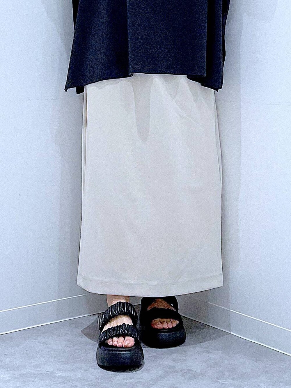 ブラック系のサンダル、ベージュ系のスカート、ホワイト系のショルダーバッグを着用したレディースの夏コーディネートの8枚目の写真