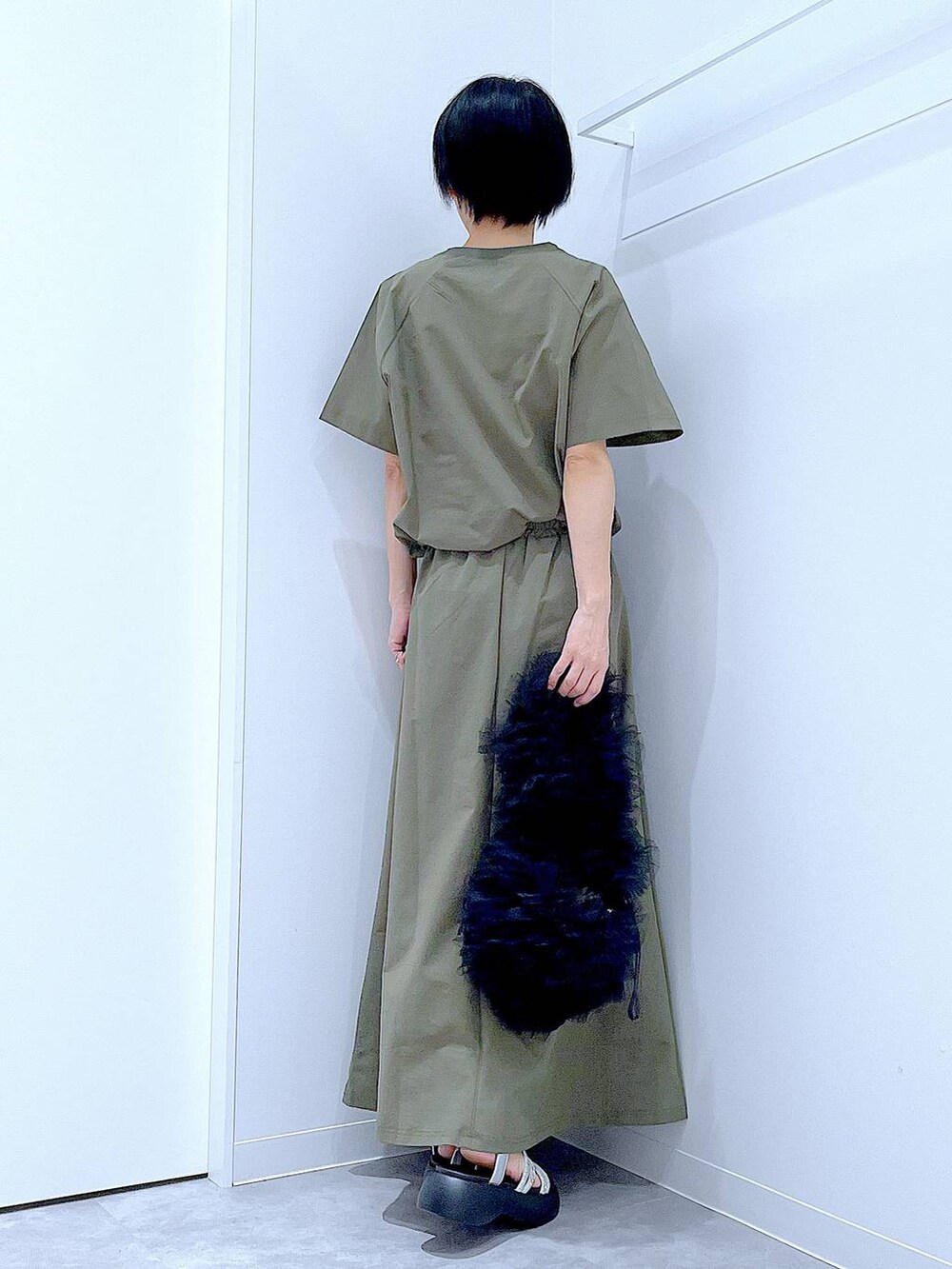 ブラック系のショルダーバッグ、シルバー系のサンダル、グリーン系のTシャツ/カットソーを着用したレディースの夏コーディネートの5枚目の写真