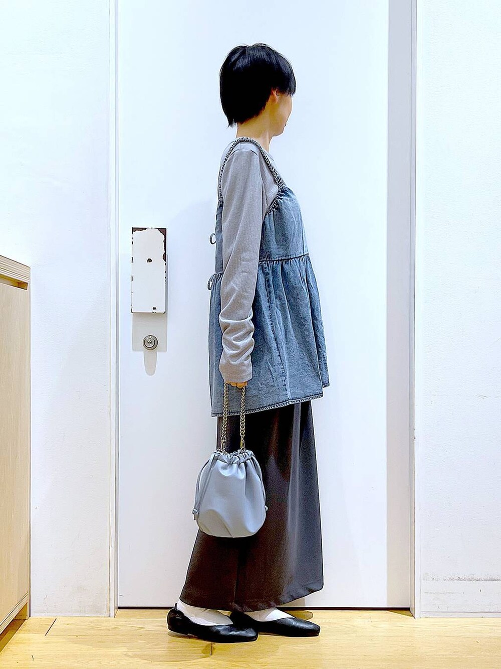 ブルー系のショルダーバッグ、ブラック系のパンプス、ブルー系のその他トップスを着用したレディースの春コーディネートの4枚目の写真
