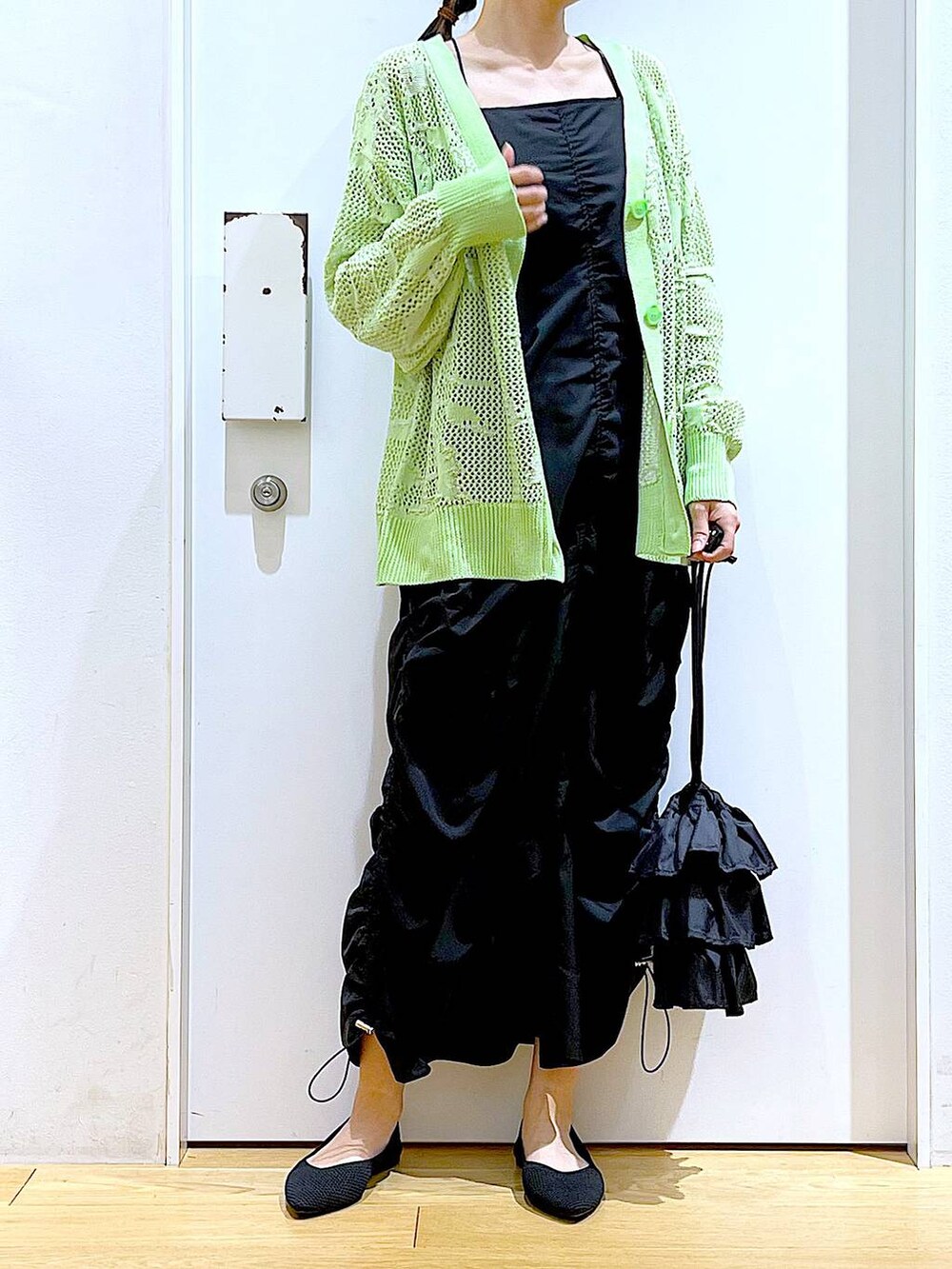 ブラック系のショルダーバッグ、ブラック系のパンプス、ブラック系のワンピースを着用したレディースの春コーディネートの6枚目の写真