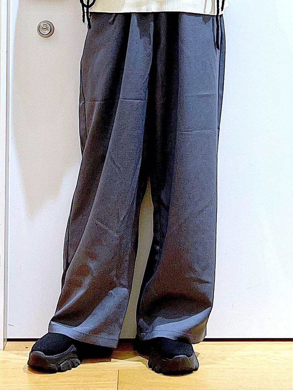 ホワイト系のショルダーバッグ、ブラック系のブーツ、グレー系のその他パンツを着用したレディースの冬コーディネートの8枚目の写真