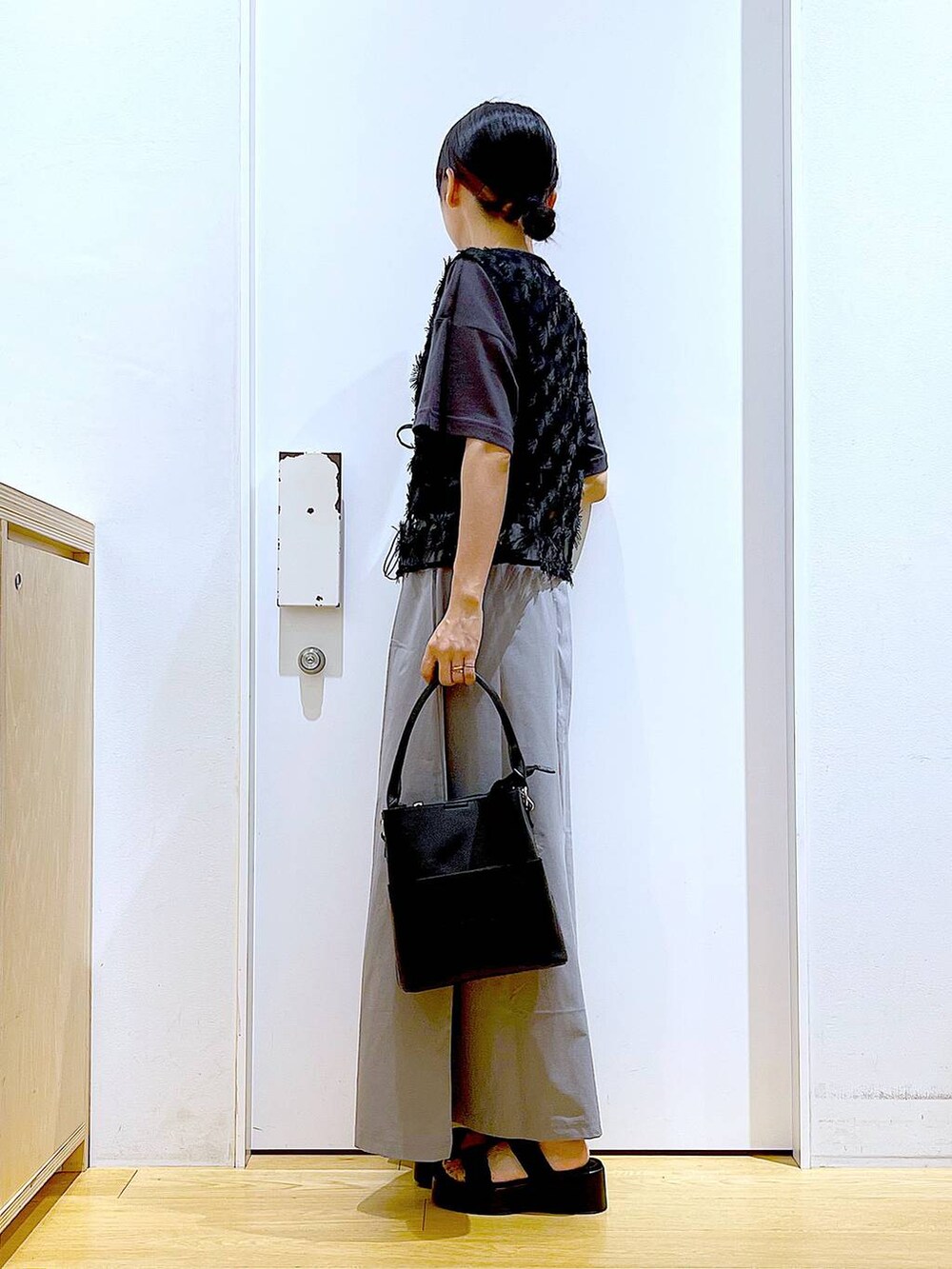 ブラック系のサンダル、ブラック系のショルダーバッグ、グレー系のスカートを着用したレディースの秋コーディネートの3枚目の写真