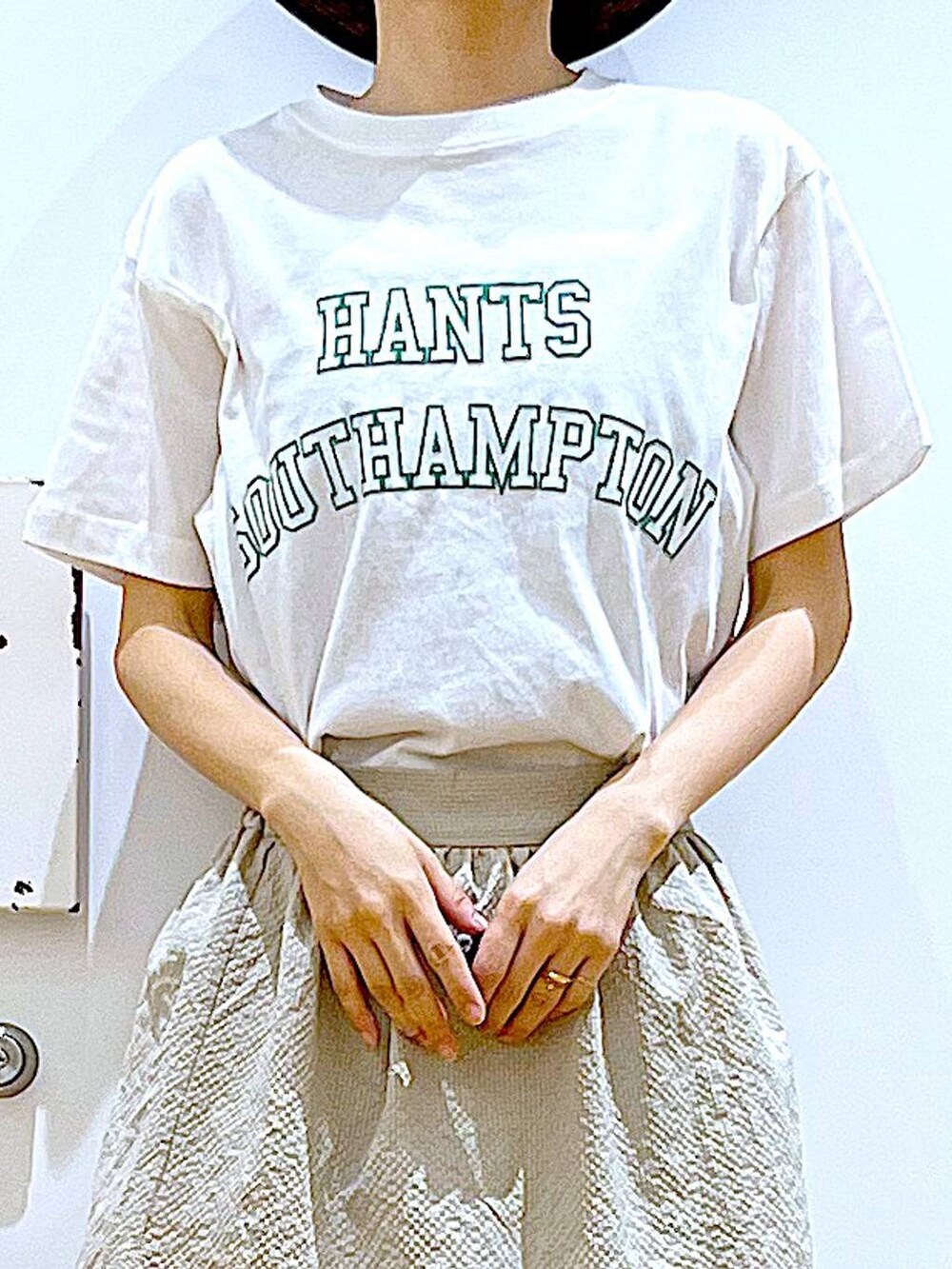 ベージュ系のスカート、ホワイト系のTシャツ/カットソー、その他のトートバッグを着用したレディースの春コーディネートの7枚目の写真
