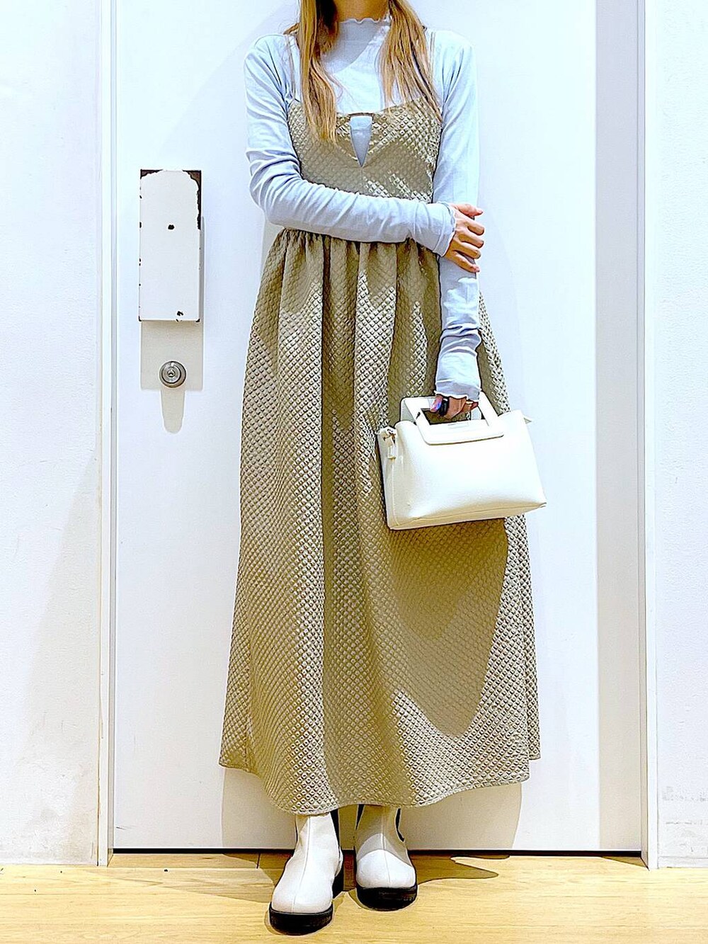 ブルー系のTシャツ/カットソー、ブラウン系のワンピース、ベージュ系のブーツを着用したレディースの冬コーディネートの2枚目の写真