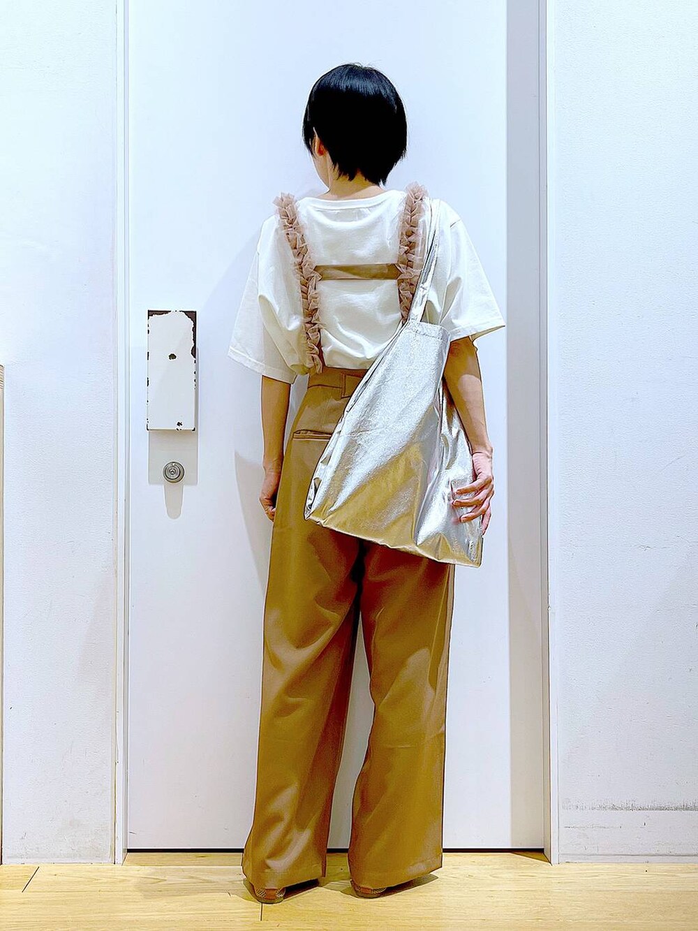 シルバー系のトートバッグ、ベージュ系のパンプス、ブラウン系のその他パンツを着用したレディースの春コーディネートの5枚目の写真