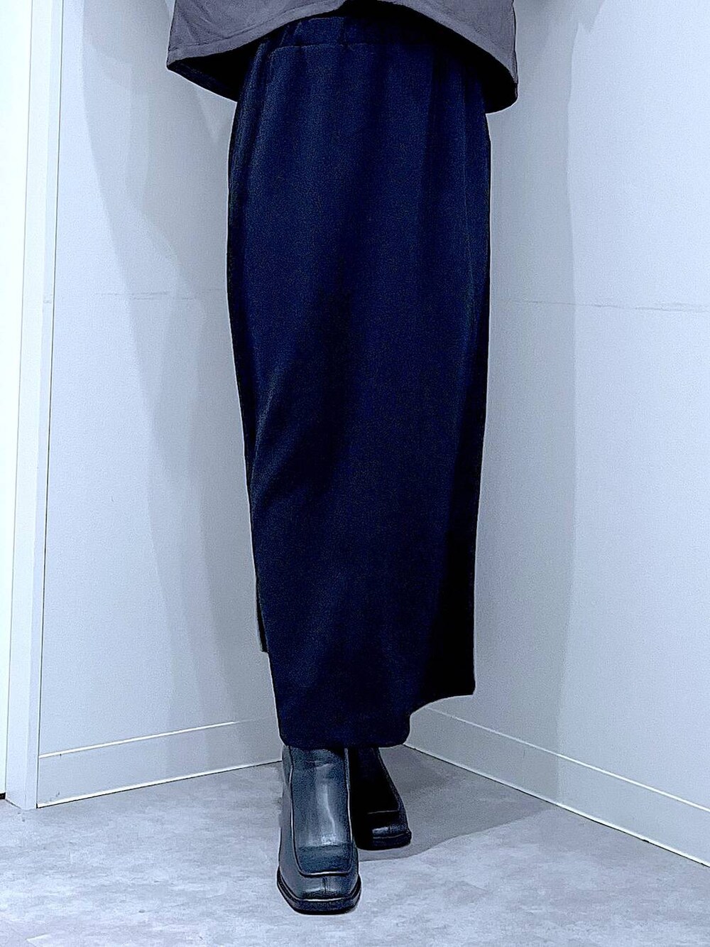 ブラック系のスカート、ブラック系のブーツ、グレー系のシャツ/ブラウスを着用したレディースの秋コーディネートの8枚目の写真