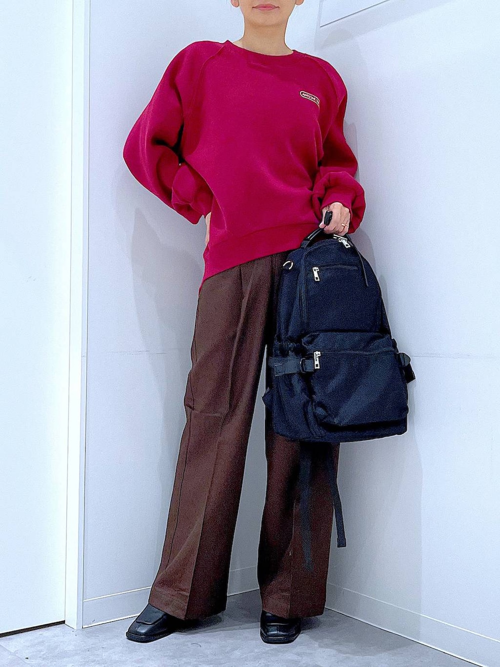 ブラック系のブーツ、ブラウン系のスラックス、ブラック系のバックパック/リュックを着用したレディースの冬コーディネートの6枚目の写真