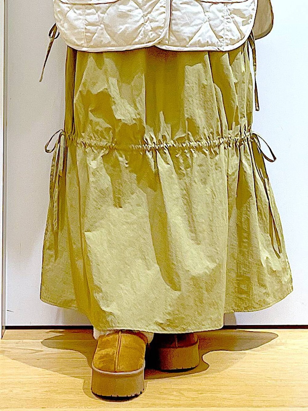 ベージュ系のブルゾン、ベージュ系のスリッポン、ホワイト系のハンドバッグを着用したレディースの秋コーディネートの8枚目の写真