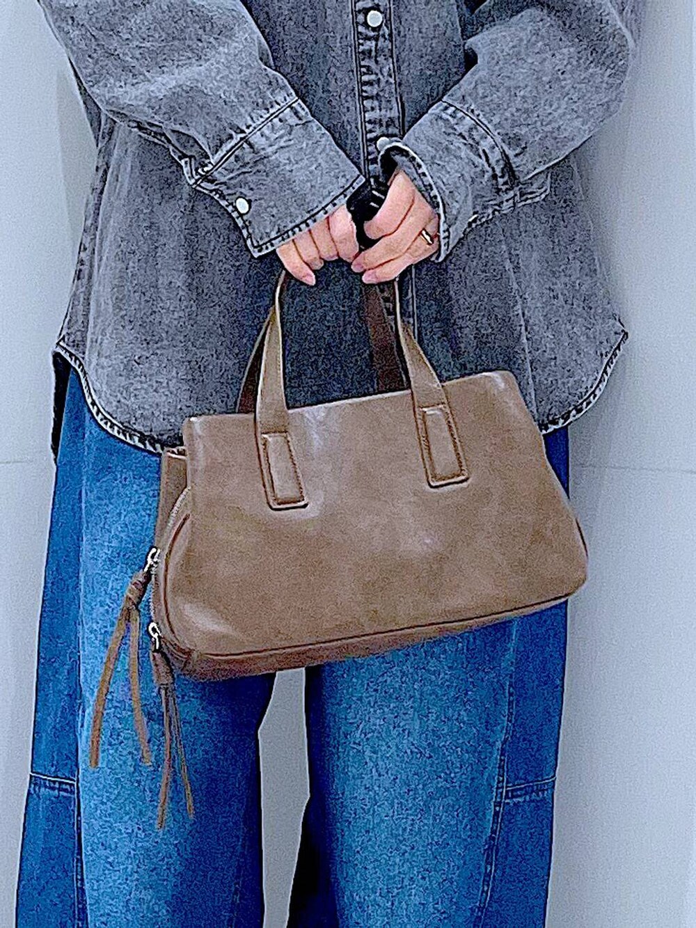 ブラウン系のボストンバッグ、ブルー系のデニムパンツ、ブラック系のシャツ/ブラウスを着用したレディースの冬コーディネートの9枚目の写真