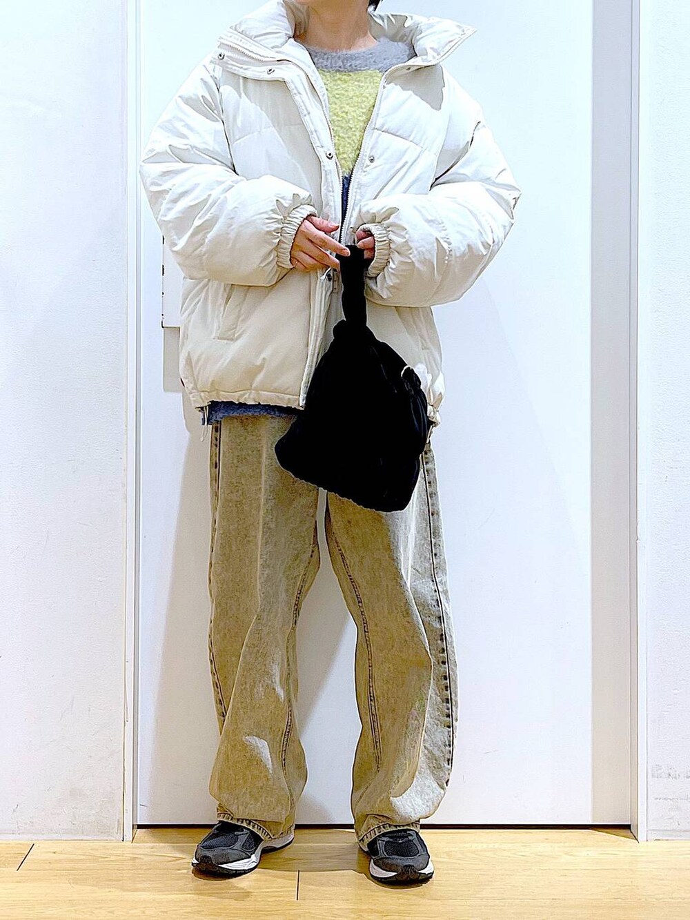 ベージュ系のブルゾン、ブラック系のショルダーバッグ、ベージュ系のデニムパンツを着用したレディースの冬コーディネートの6枚目の写真