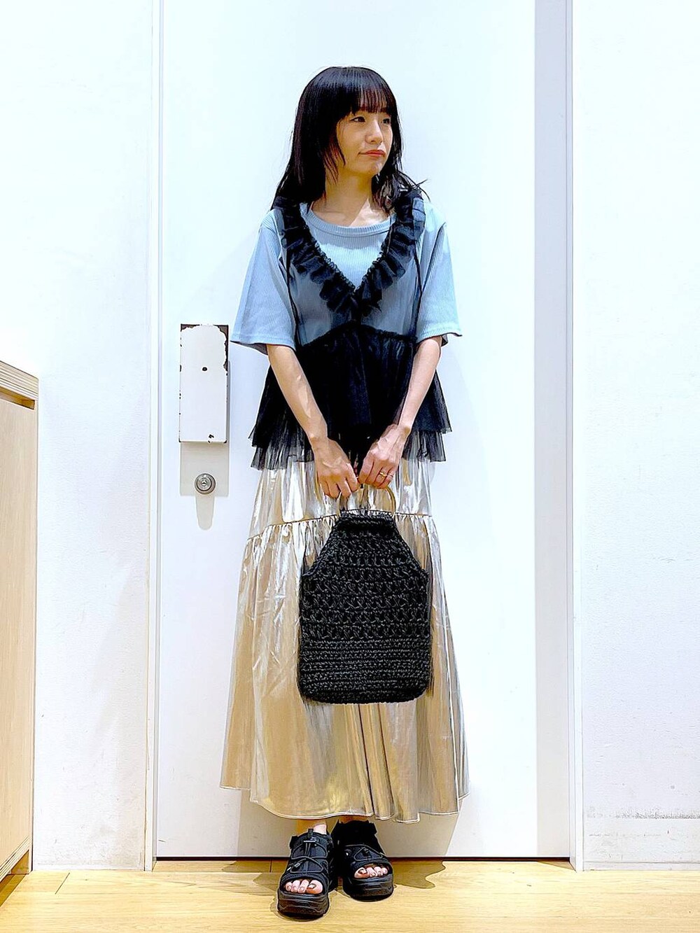 ブラック系のサンダル、ブルー系のTシャツ/カットソー、ブラック系のベストを着用したレディースの夏コーディネートの2枚目の写真