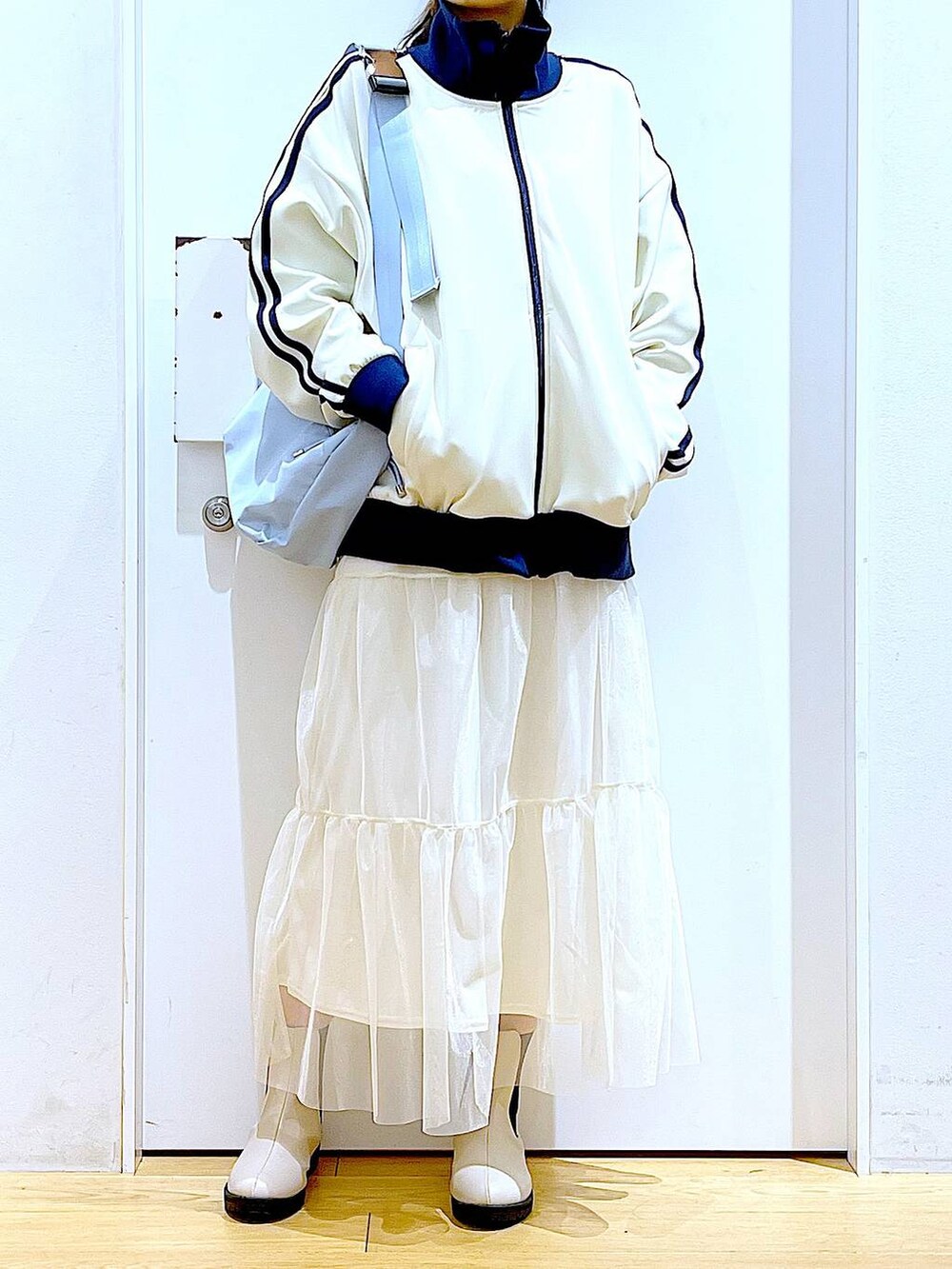 ベージュ系のブーツ、ブルー系のショルダーバッグ、ベージュ系のスウェットを着用したレディースの春コーディネートの6枚目の写真