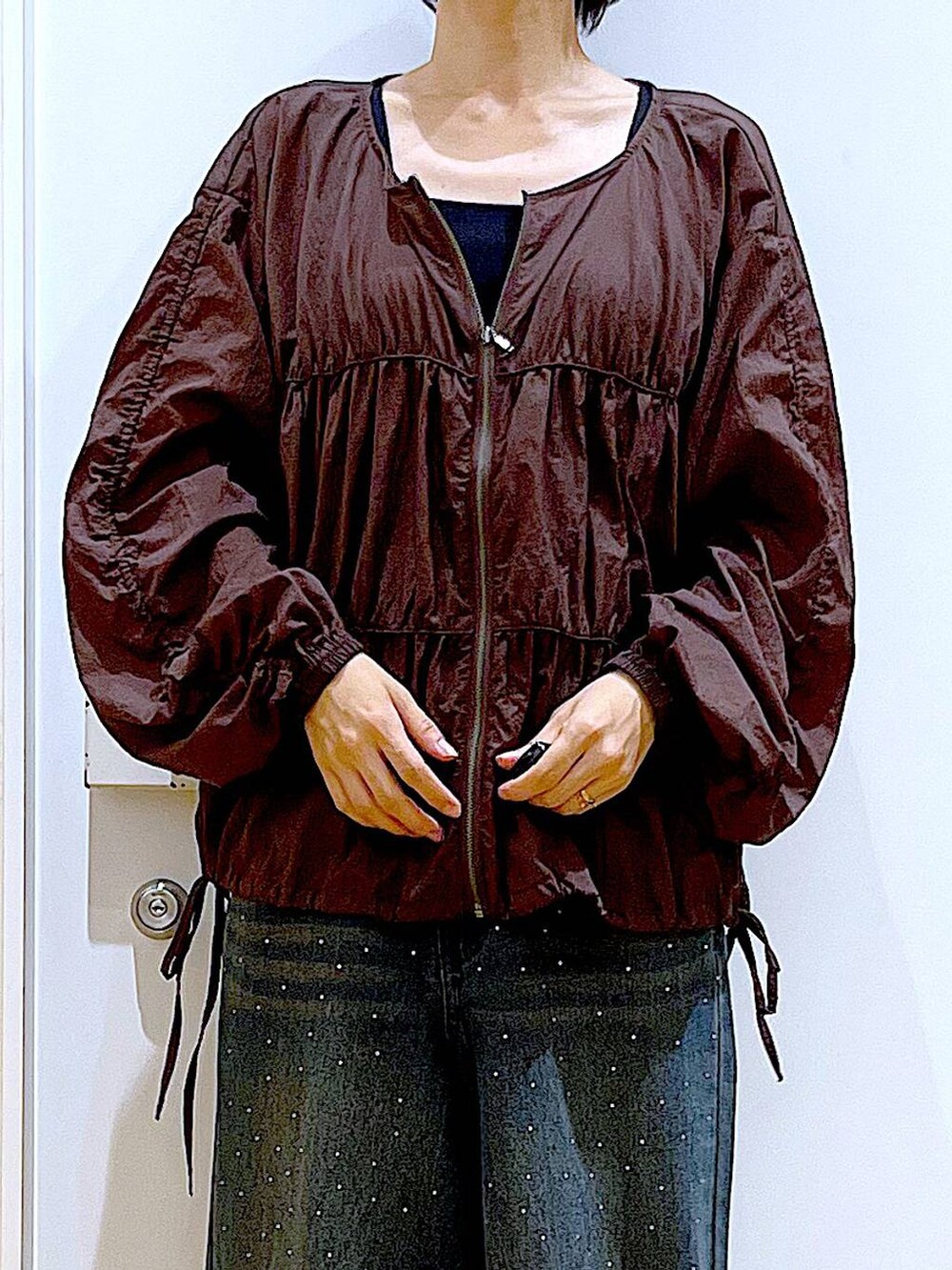 ブラック系のブーツ、ベージュ系のトートバッグ、ブラウン系のブルゾンを着用したレディースの冬コーディネートの7枚目の写真