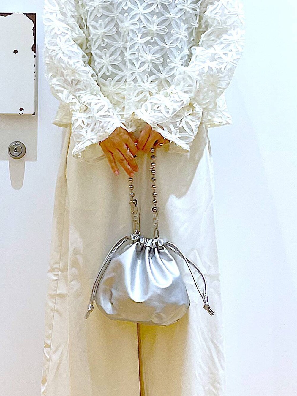 シルバー系のショルダーバッグ、ホワイト系のその他パンツ、シルバー系のパンプスを着用したレディースの秋コーディネートの9枚目の写真