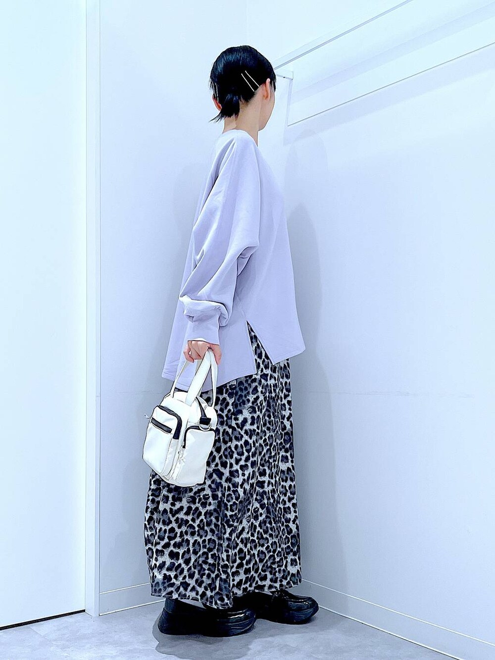 ホワイト系のショルダーバッグ、ブラック系のローファー、グレー系のスカートを着用したレディースの秋コーディネートの4枚目の写真