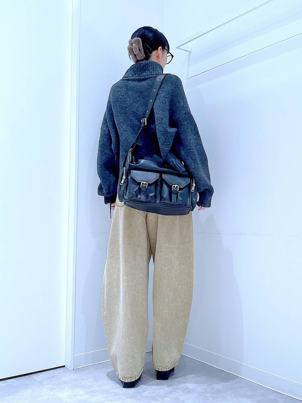 ベージュ系のデニムパンツ、ブラック系のブーツ、グレー系のニット/セーターを着用したレディースの冬コーディネートの5枚目の写真