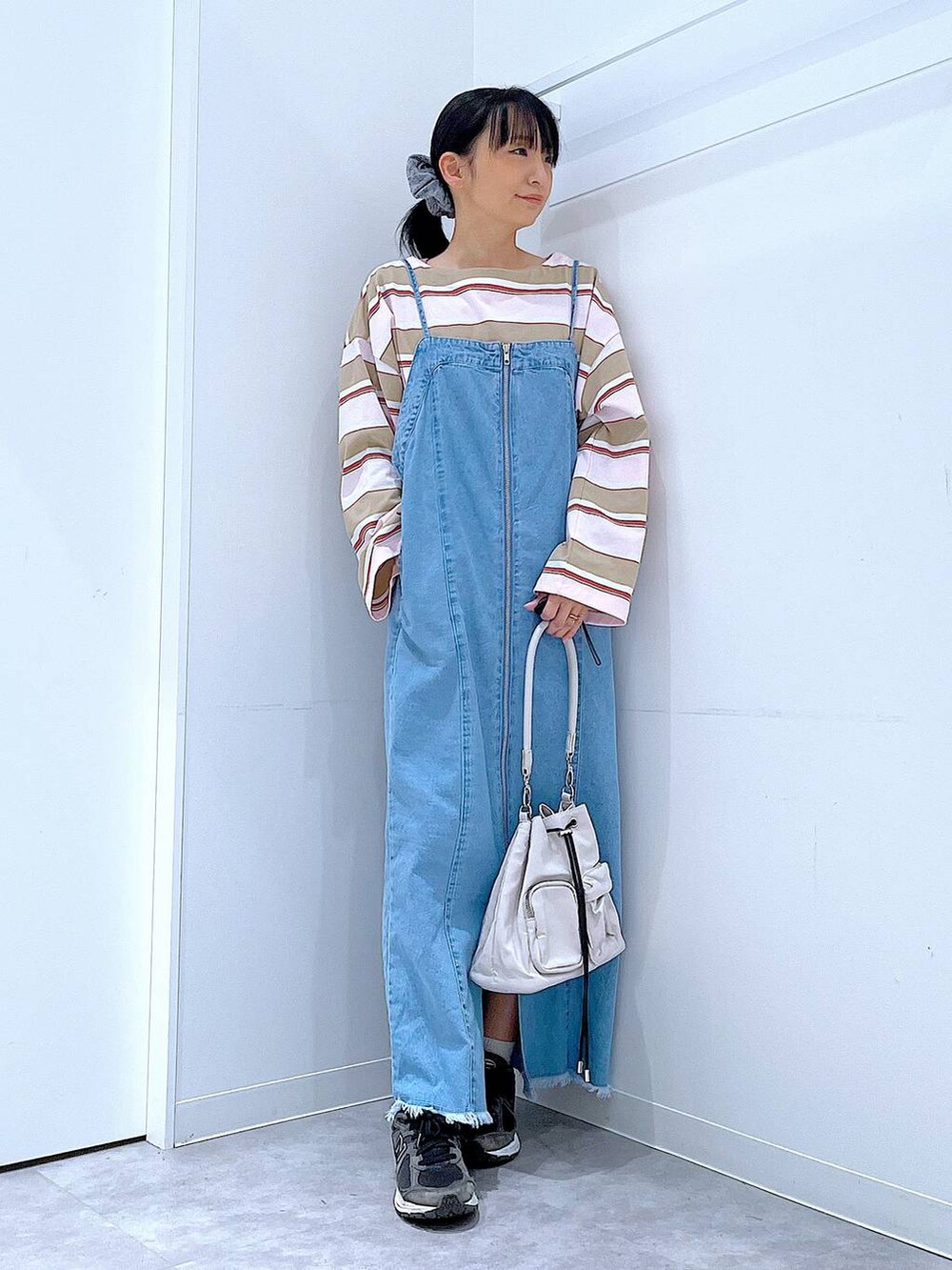 ホワイト系のショルダーバッグ、ピンク系のTシャツ/カットソー、グレー系のシュシュを着用したレディースの春コーディネートの2枚目の写真