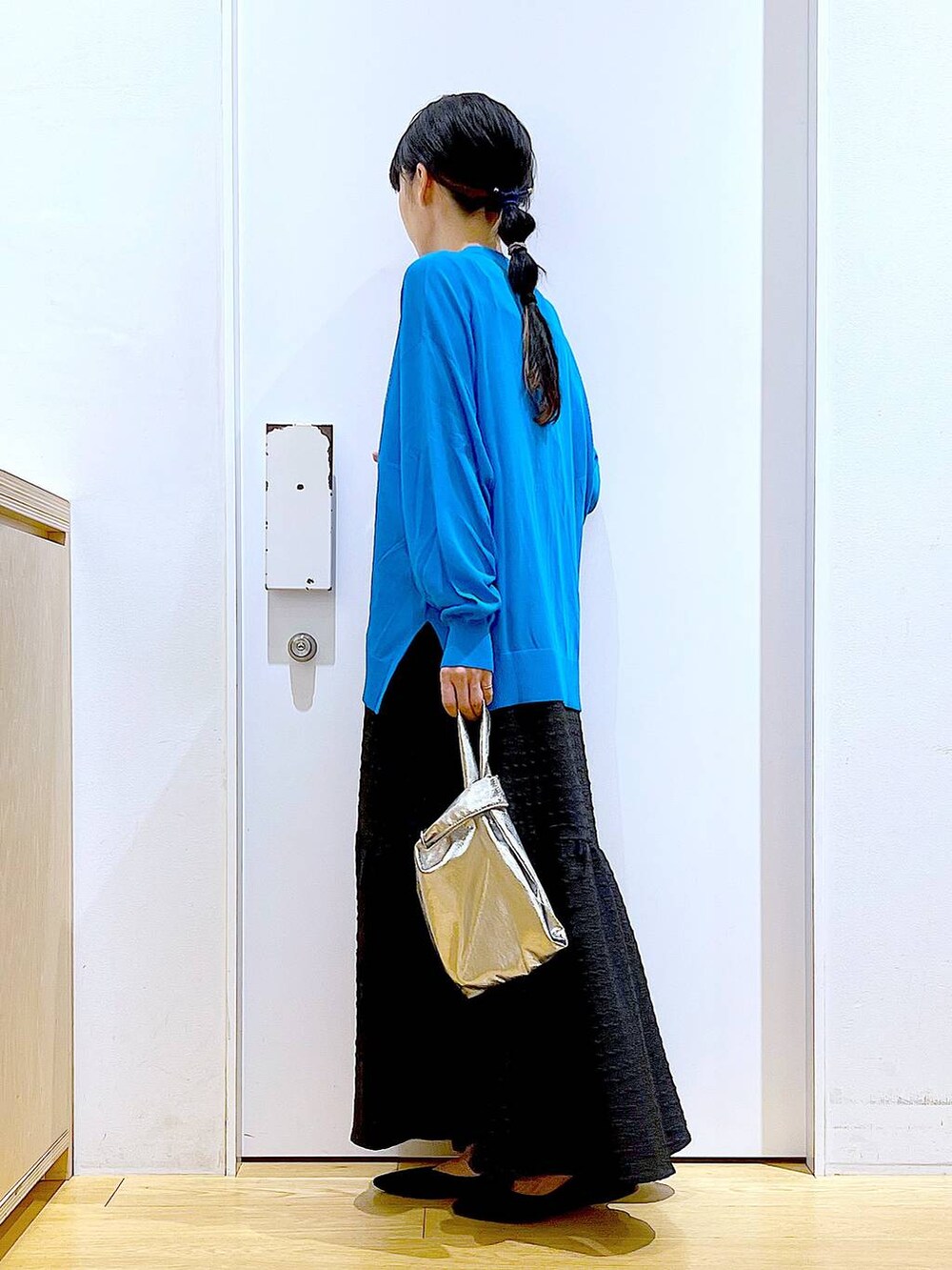 シルバー系のショルダーバッグ、ブラック系のワンピース、ブラック系のパンプスを着用したレディースの春コーディネートの3枚目の写真