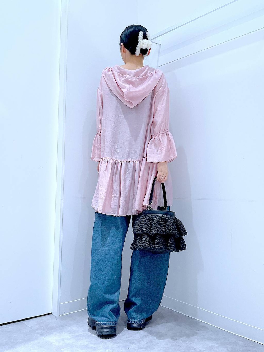 ブルー系のデニムパンツ、ブラック系のスニーカー、ブラック系のショルダーバッグを着用したレディースの春コーディネートの5枚目の写真