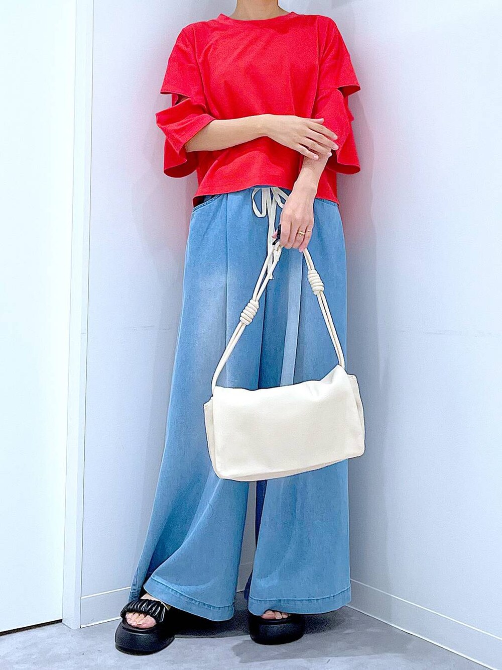 ブラック系のサンダル、レッド系のTシャツ/カットソー、ホワイト系のショルダーバッグを着用したレディースの夏コーディネートの6枚目の写真