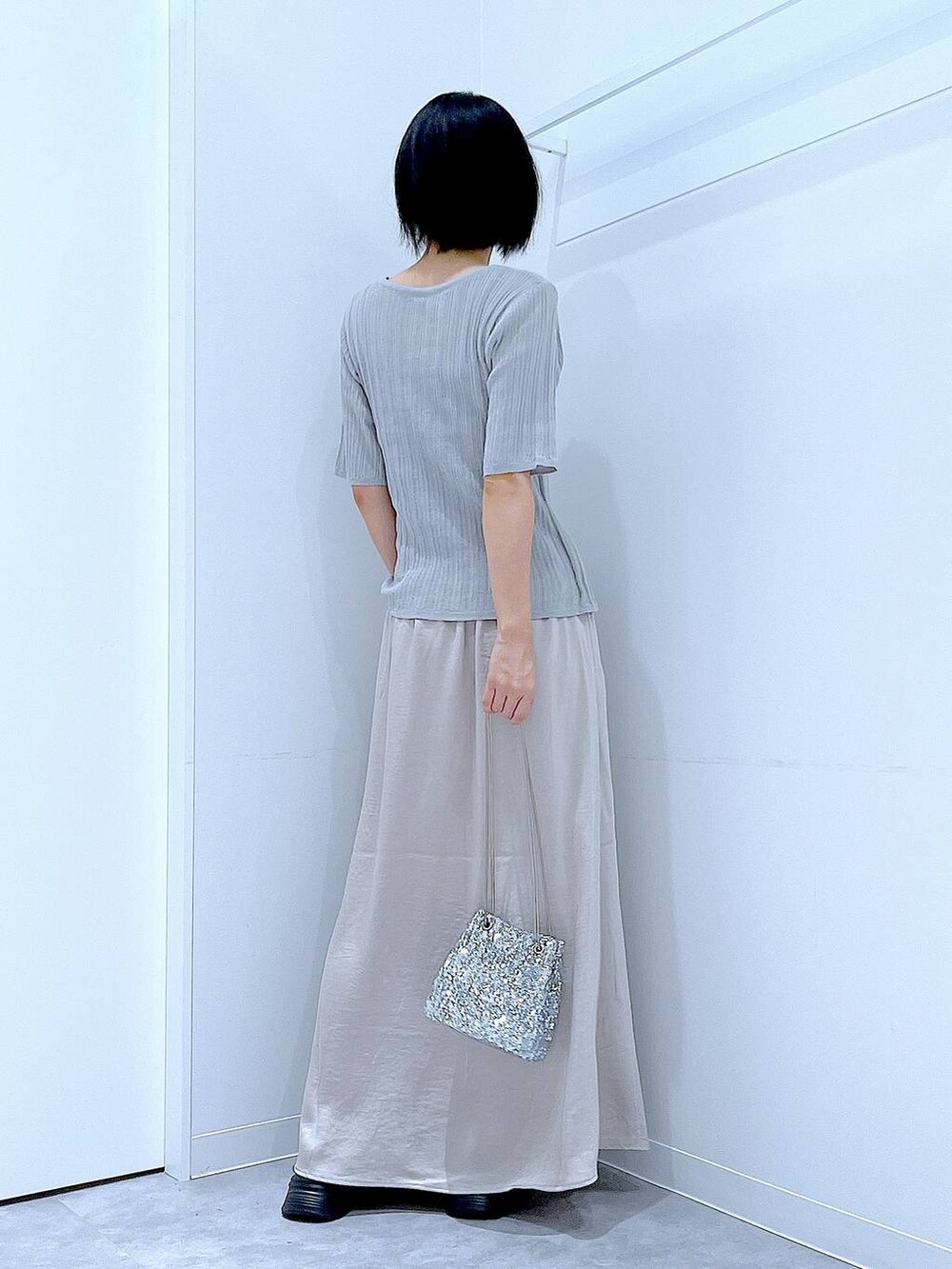 シルバー系のショルダーバッグ、ブラック系のローファー、グレー系のニット/セーターを着用したレディースの秋コーディネートの5枚目の写真