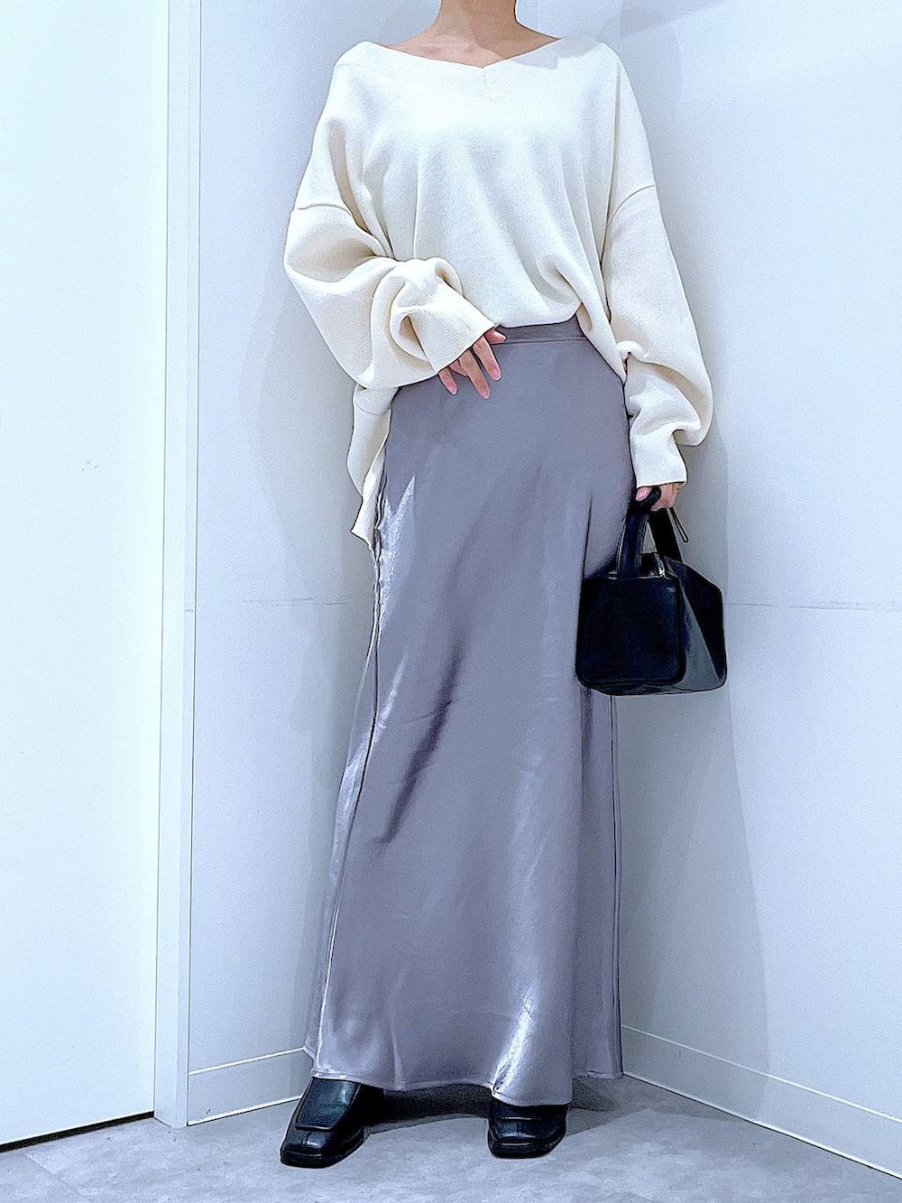 ベージュ系のニット/セーター、ブラック系のブーツ、ブラック系のショルダーバッグを着用したレディースの冬コーディネートの6枚目の写真