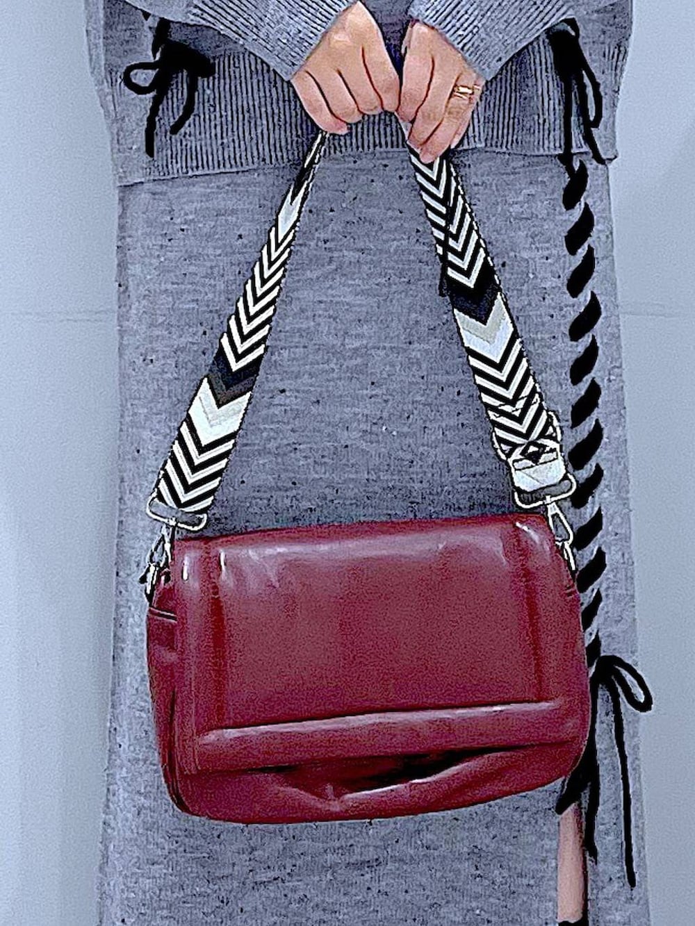 グレー系のニット/セーター、レッド系のショルダーバッグ、グレー系のスカートを着用したレディースの冬コーディネートの9枚目の写真