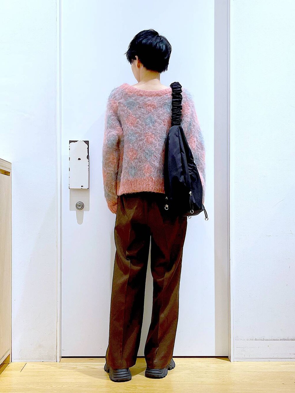 ブラック系のブーツ、ブラック系のショルダーバッグ、ピンク系のニット/セーターを着用したレディースの冬コーディネートの5枚目の写真