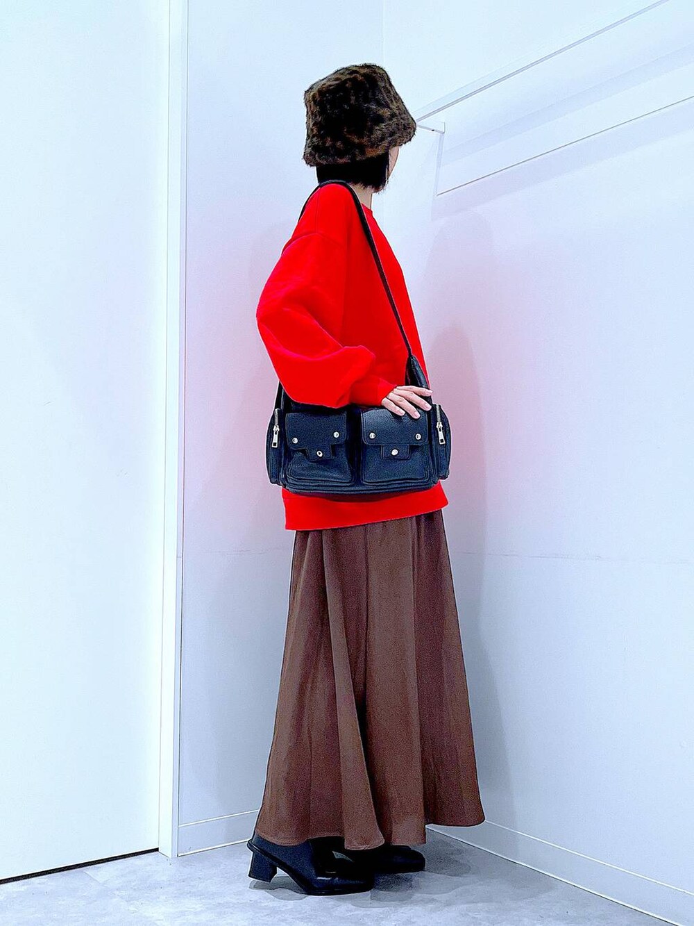 ブラック系のショルダーバッグ、ブラック系のブーツ、レッド系のスウェットを着用したレディースの秋コーディネートの4枚目の写真