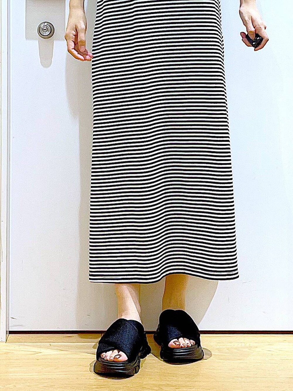 ブラック系のショルダーバッグ、ブラック系のサンダル、ブラック系のワンピースを着用したレディースの夏コーディネートの8枚目の写真