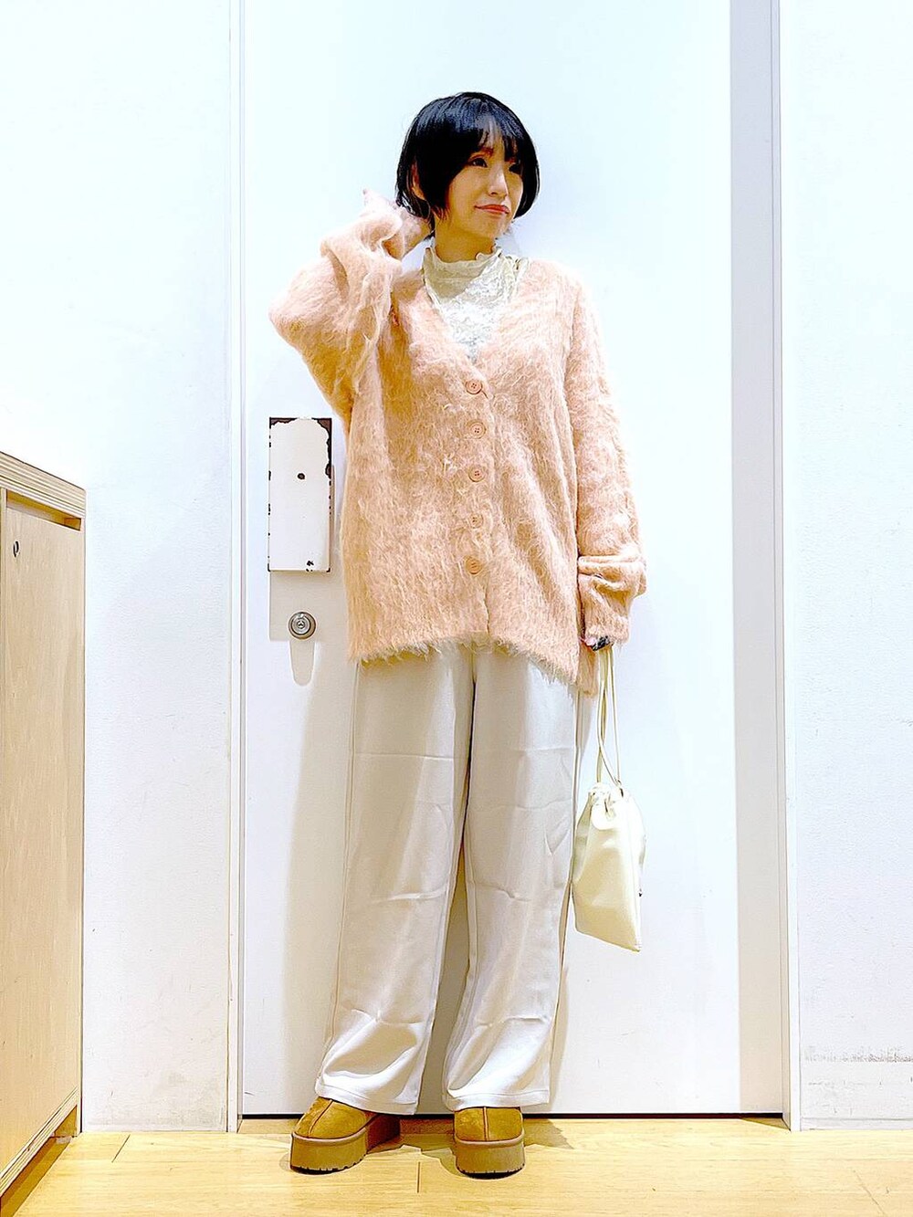 ピンク系のカーディガン/ボレロ、ホワイト系のショルダーバッグ、ホワイト系のTシャツ/カットソーを着用したレディースの冬コーディネートの2枚目の写真