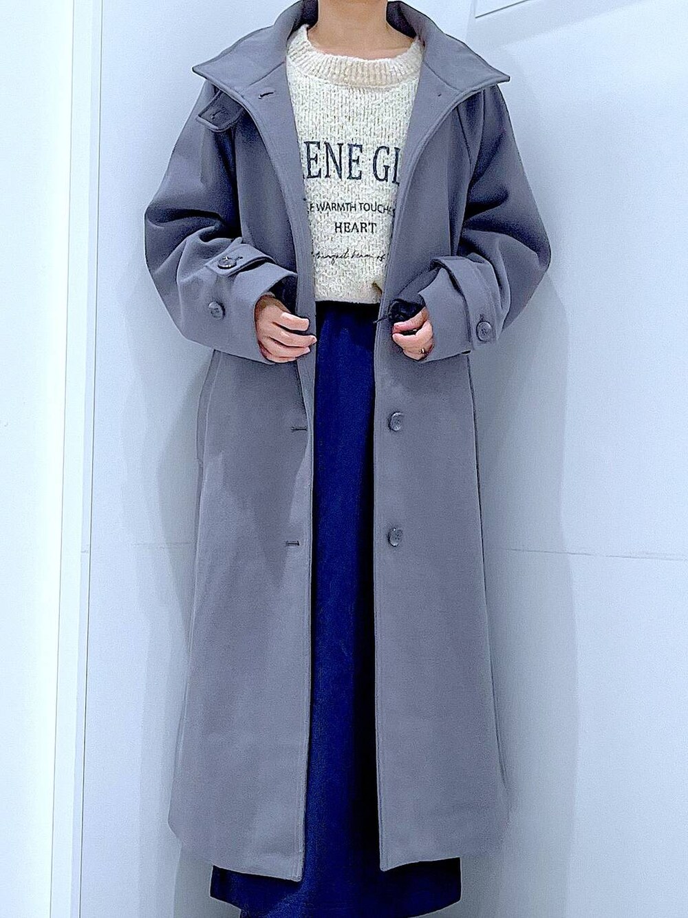 グレー系のその他アウター、ホワイト系のニット/セーター、ブルー系のスカートを着用したレディースの秋コーディネートの7枚目の写真