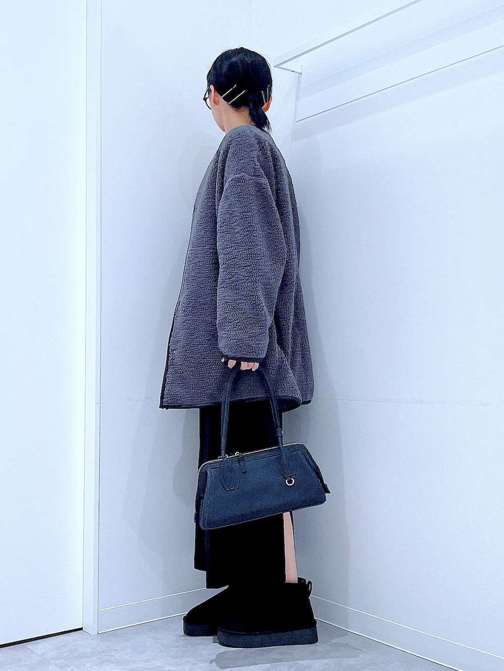 ブラック系のスカート、グレー系のブルゾン、ブラック系のブーツを着用したレディースの秋コーディネートの3枚目の写真