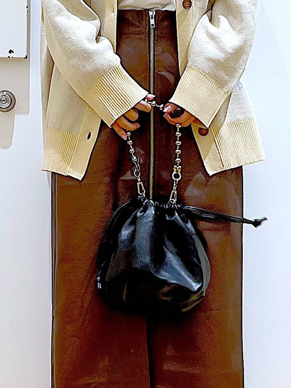 ブラウン系のスカート、ブラック系のショルダーバッグ、ブラック系のパンプスを着用したレディースの秋コーディネートの9枚目の写真