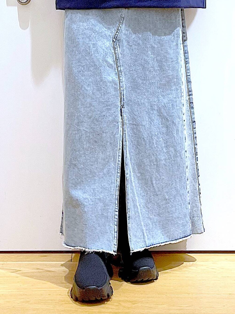 ブルー系のショルダーバッグ、ブラック系のブーツ、ブルー系のデニムスカートを着用したレディースの春コーディネートの8枚目の写真