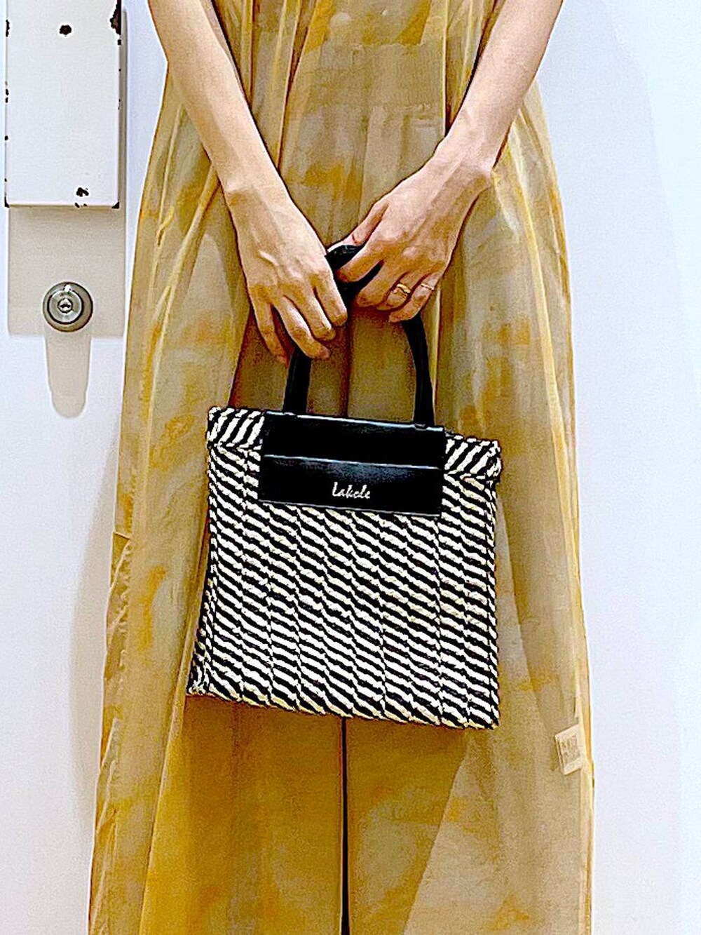 シルバー系のサンダル、オレンジ系のワンピース、ブラック系のショルダーバッグを着用したレディースの夏コーディネートの9枚目の写真