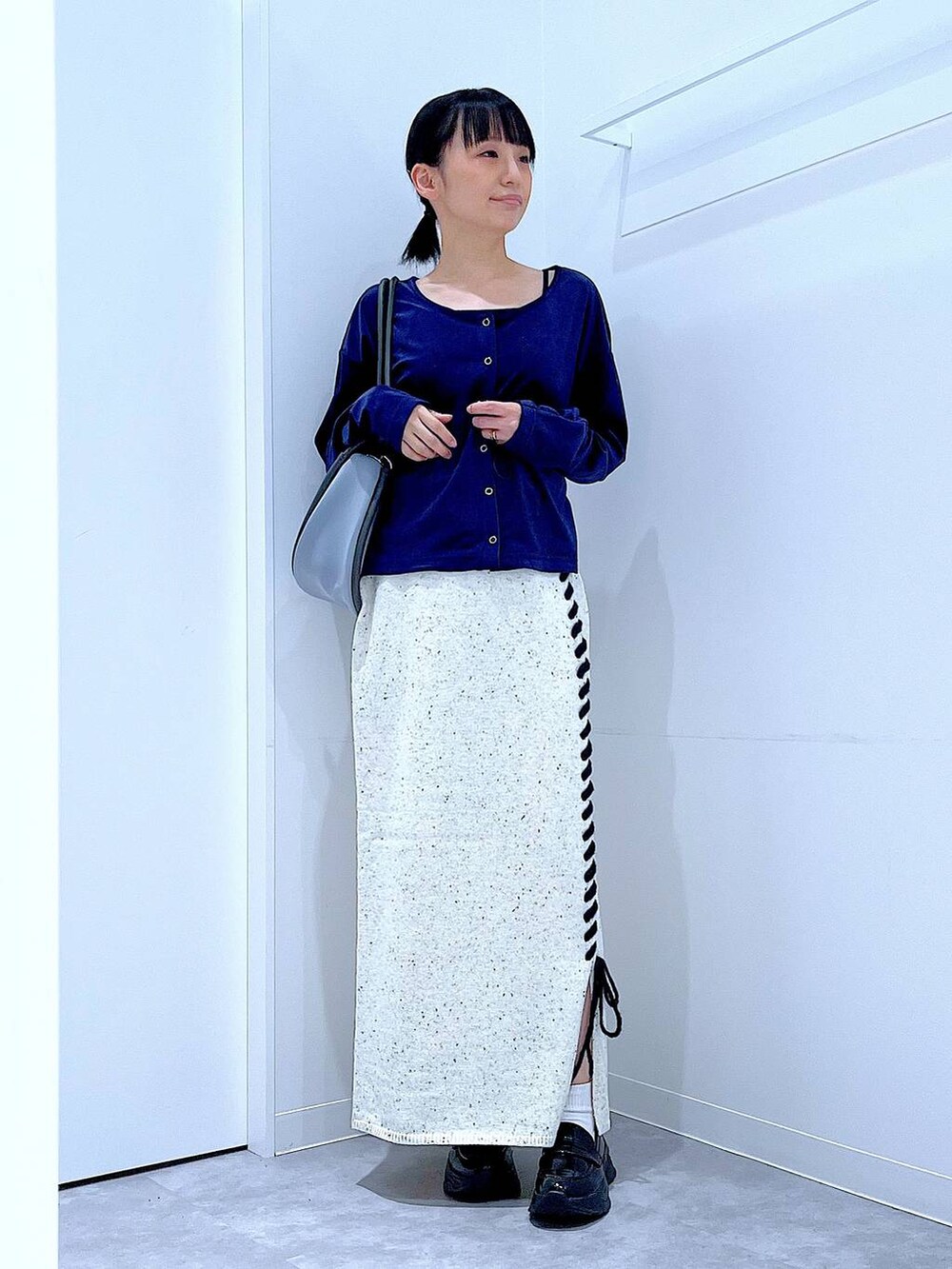 ブラック系のローファー、ブルー系のTシャツ/カットソー、グレー系のショルダーバッグを着用したレディースの秋コーディネートの2枚目の写真