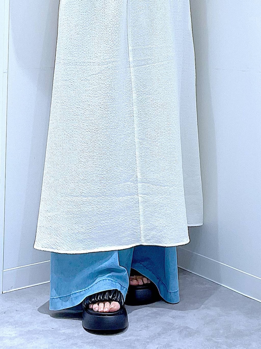 ブラック系のサンダル、ブルー系のデニムパンツ、ベージュ系のワンピースを着用したレディースの夏コーディネートの8枚目の写真