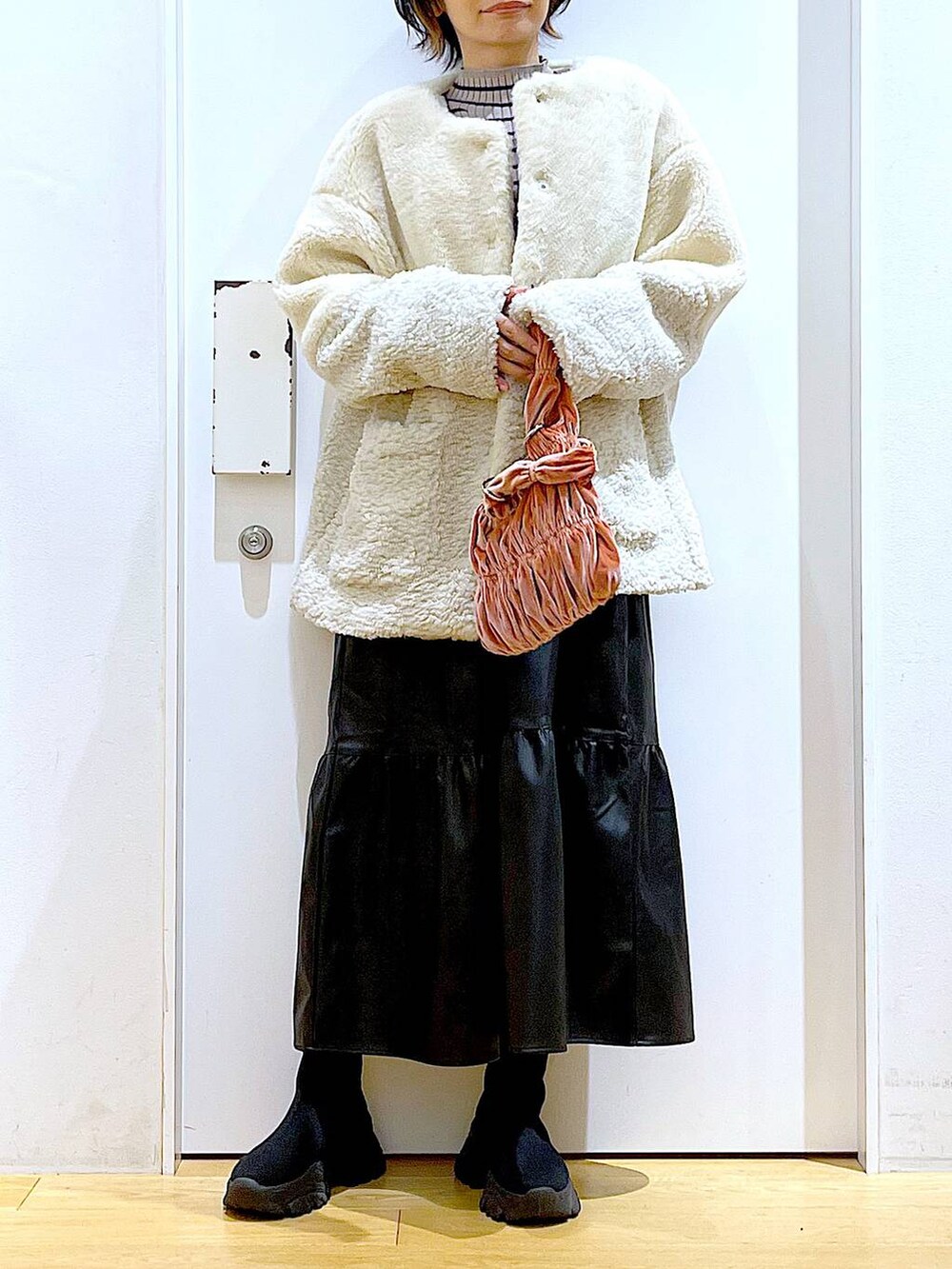 その他のニット/セーター、ピンク系のショルダーバッグ、ブラック系のブーツを着用したレディースの冬コーディネートの6枚目の写真